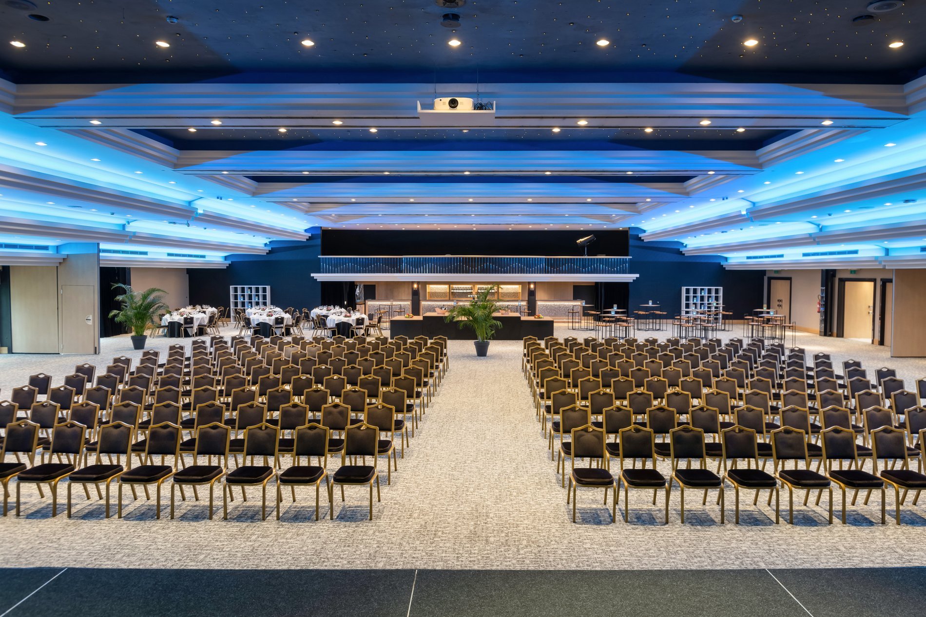 Large modern conference room with rows of chairs and blue lighting at Martin's Château du Lac.