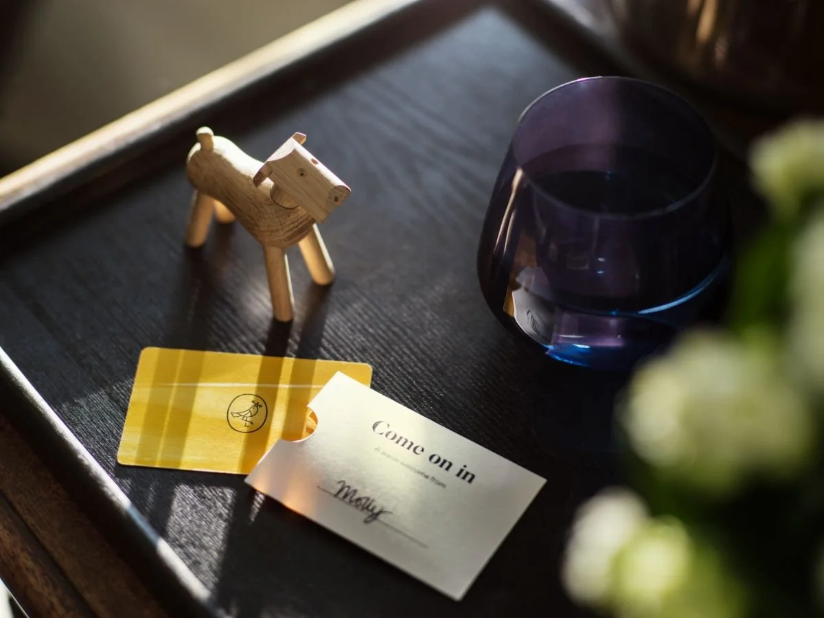 Detail of a bedside table with a lamp, cards, and a vase in a room at Hôtel VOCO Paris Montparnasse.