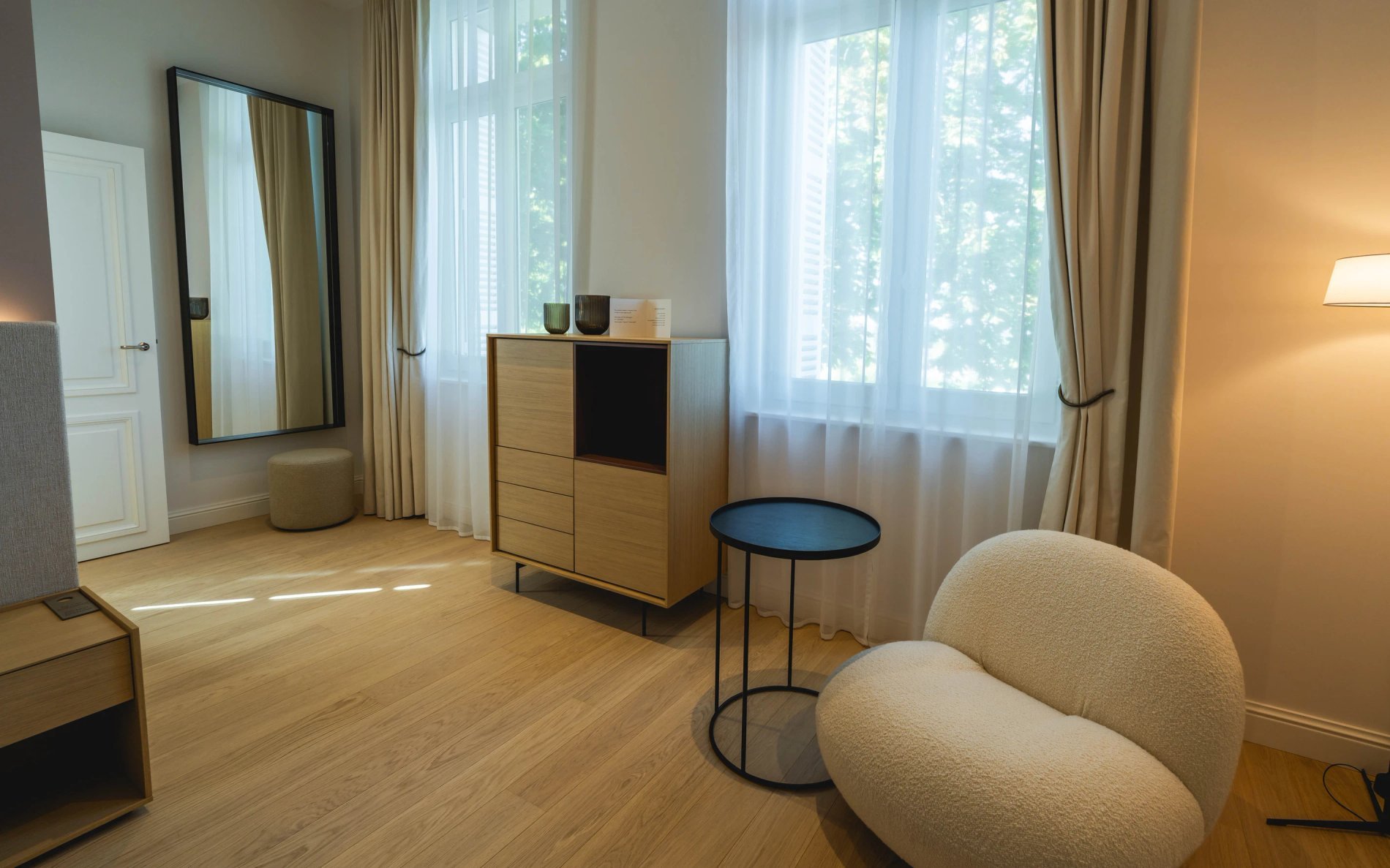 Vue sur l’espace de vie et miroir de la Chambre Charme à la Villa des Vignes