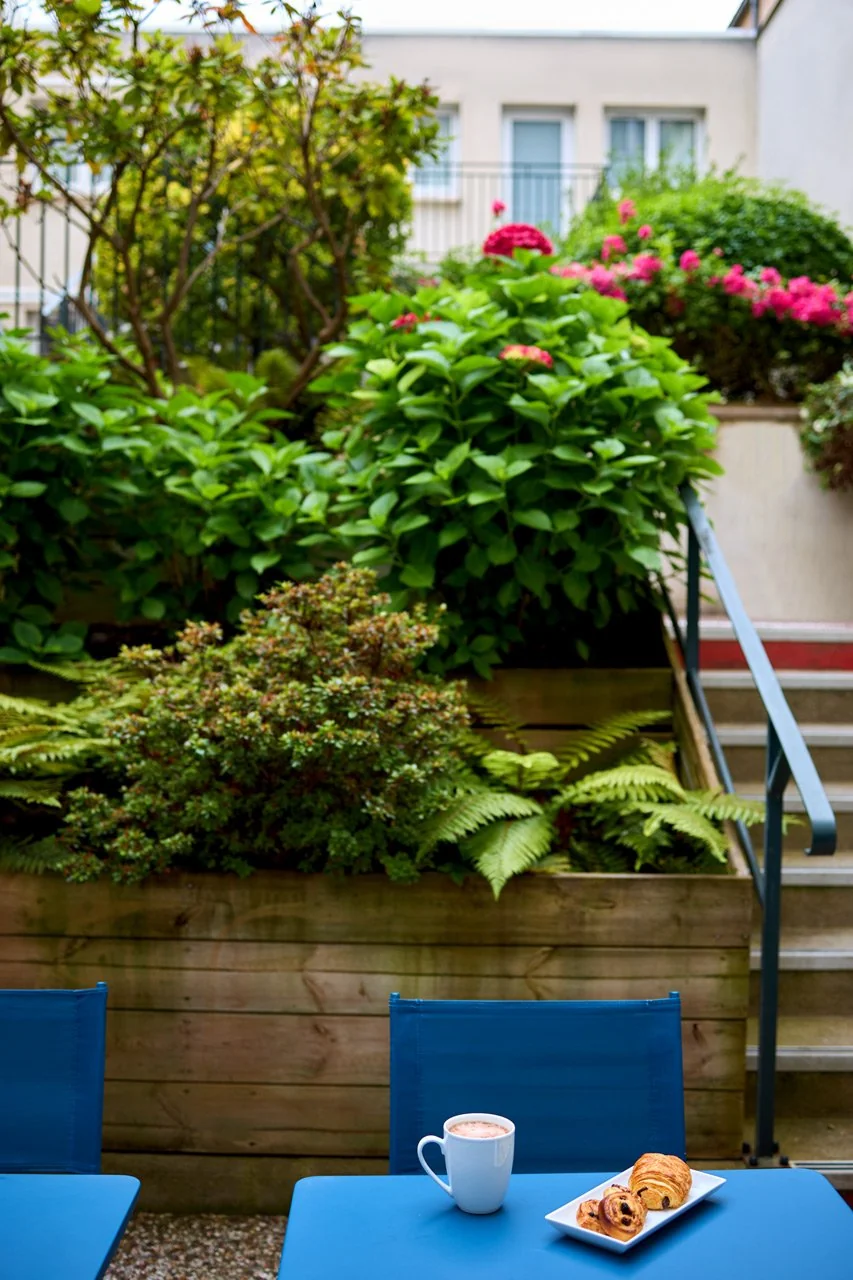 Petit déjeuner servi en terrasse avec vue sur le jardin au Timhotel Nation
