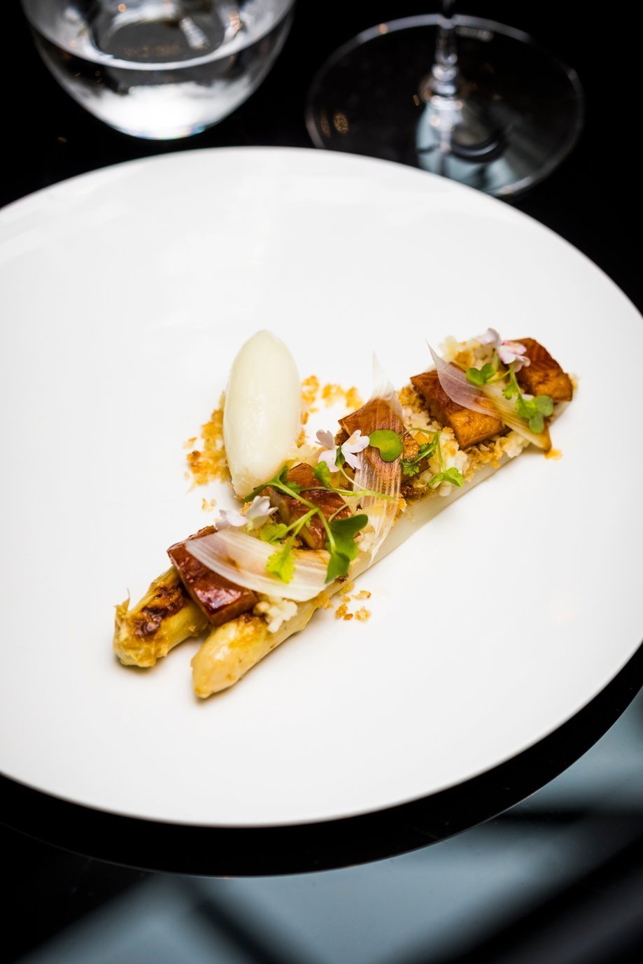 Plat raffiné mêlant textures croquantes et fondantes, présenté sur assiette blanche au sein de l’Hôtel San Régis.