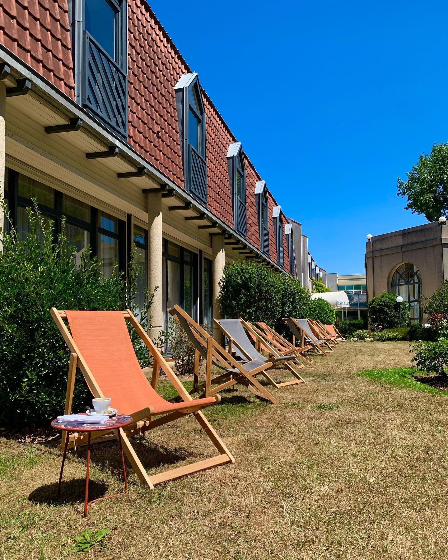 Holiday Inn Resort Le Touquet : Vue de l'extérieur de l'hôtel avec sa pelouse verdoyante et ses chaises longues, illustrant le cadre reposant de cet Hôtel 4 étoiles Le Touquet Paris Plage.