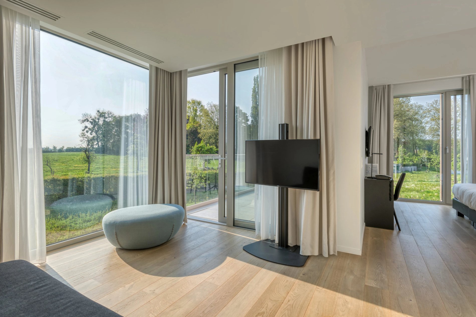Lichte zithoek in de Exceptional Garden kamer met grote ramen.
