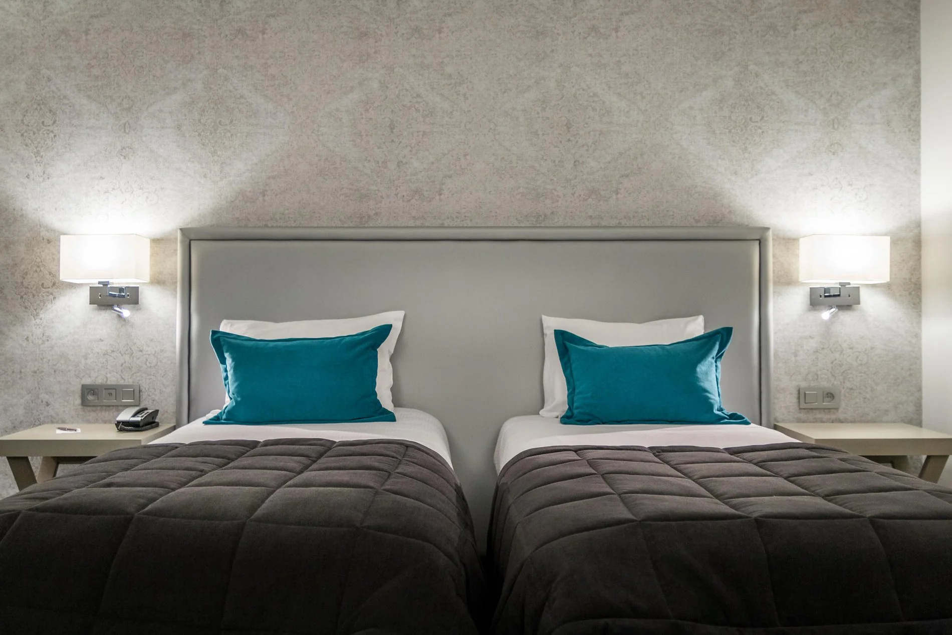 Tweepersoonskamer met twee aparte bedden, elegante inrichting en blauwe kussens bij Martin's Château du Lac.