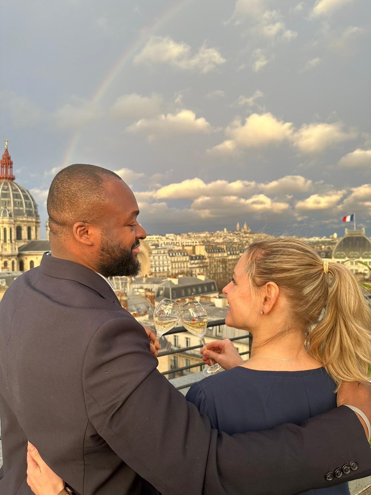Couple enlacé admirant la vue panoramique de Paris depuis la terrasse de l'hôtel Bowmann.