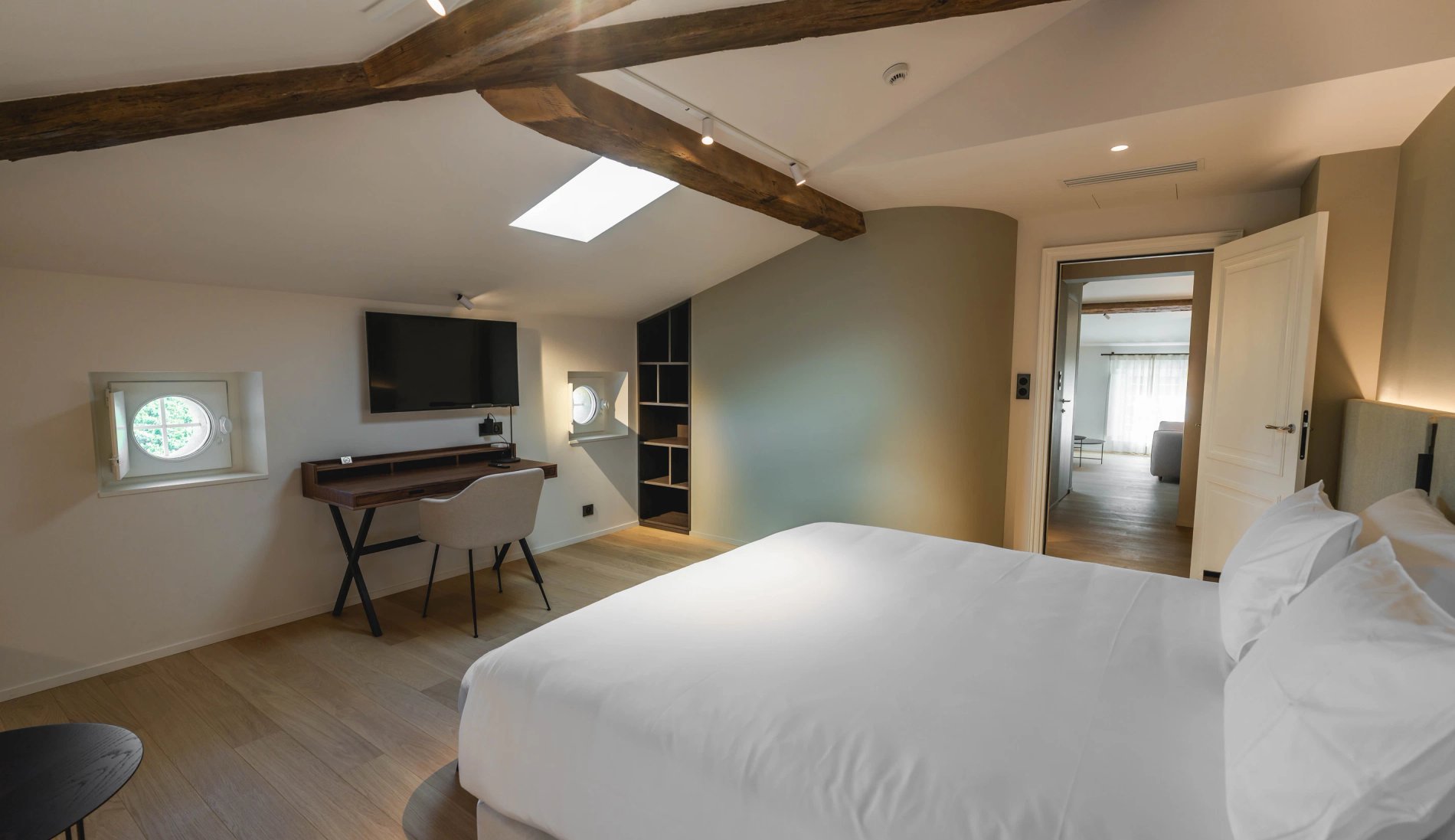 Chambre lumineuse avec bureau et coin détente dans la Suite Prestige de la Villa des Vignes