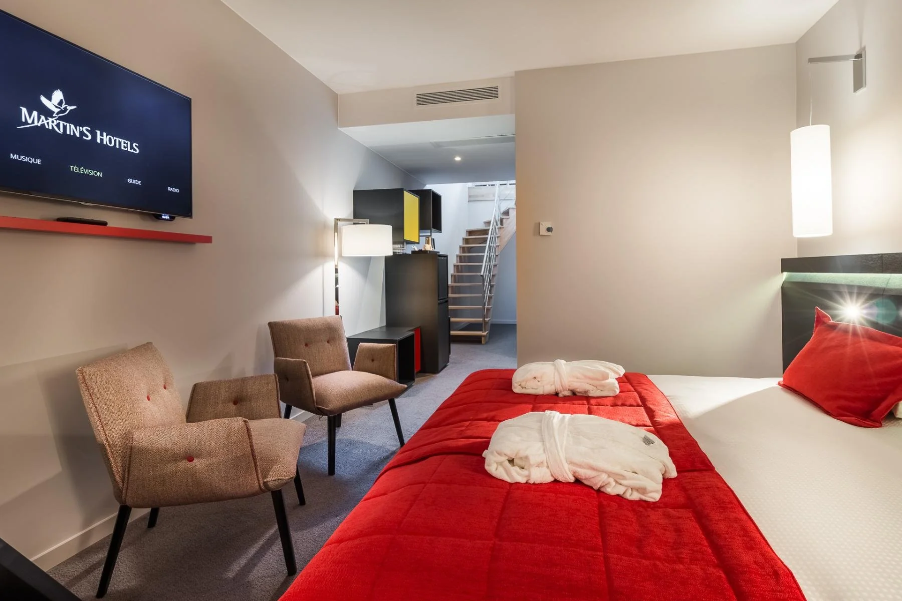 Chambre confortable avec vue sur la télévision et literie rouge