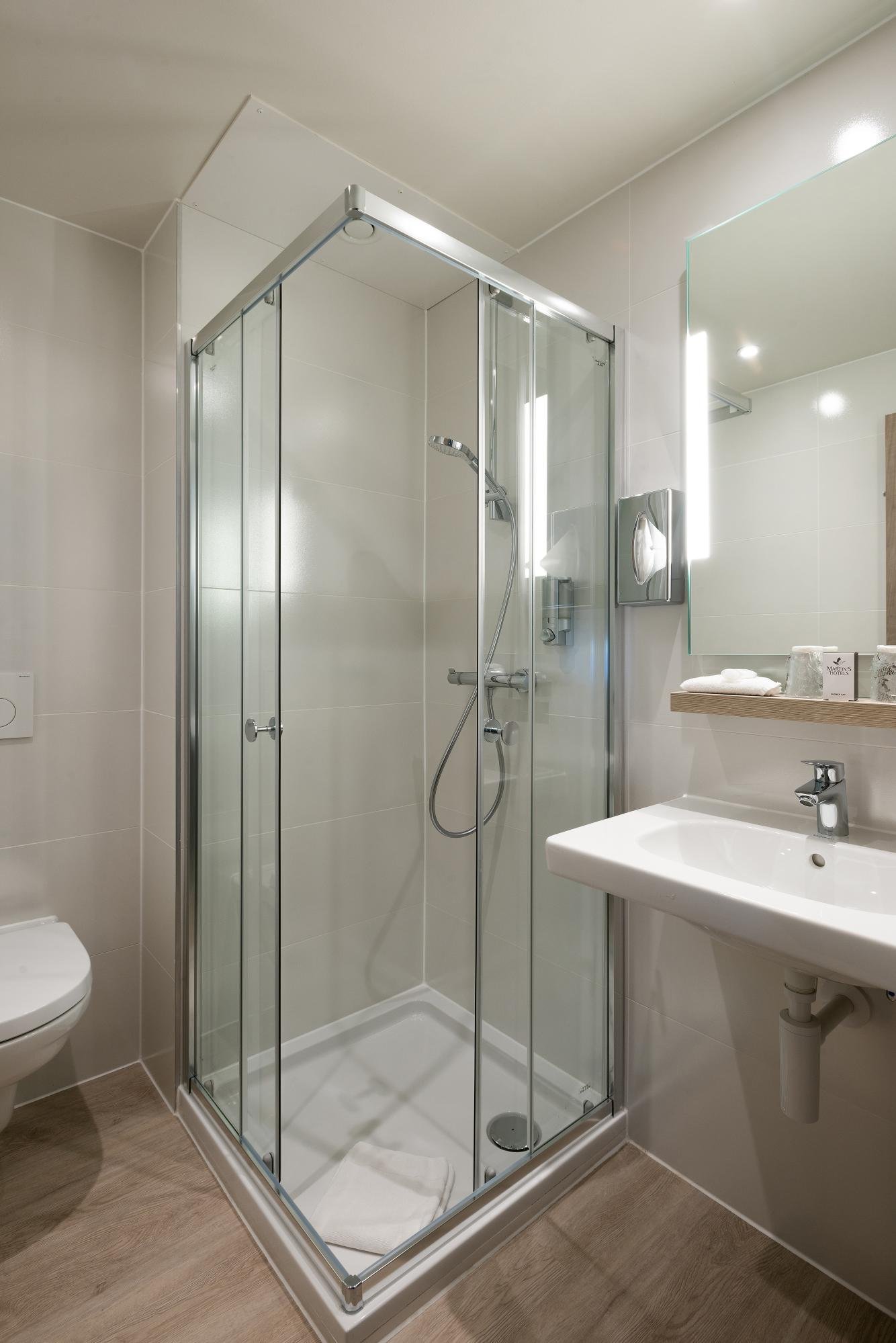 Begehbare Dusche und modernes Waschbecken im Badezimmer des Martin's Brugge