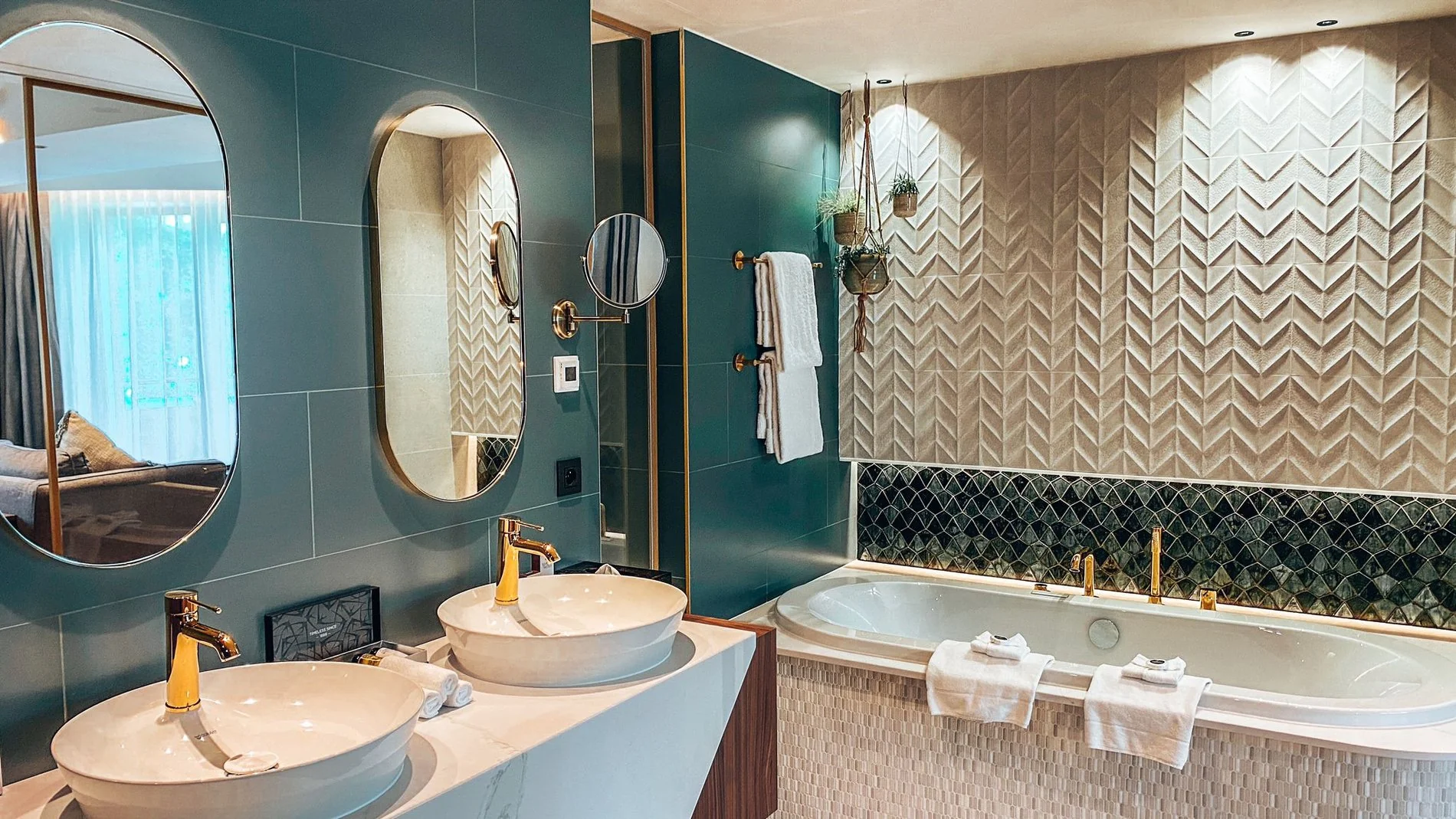 Moderne badkamer met dubbele wastafel, designspiegel en bad bij Martin's Château du Lac.
