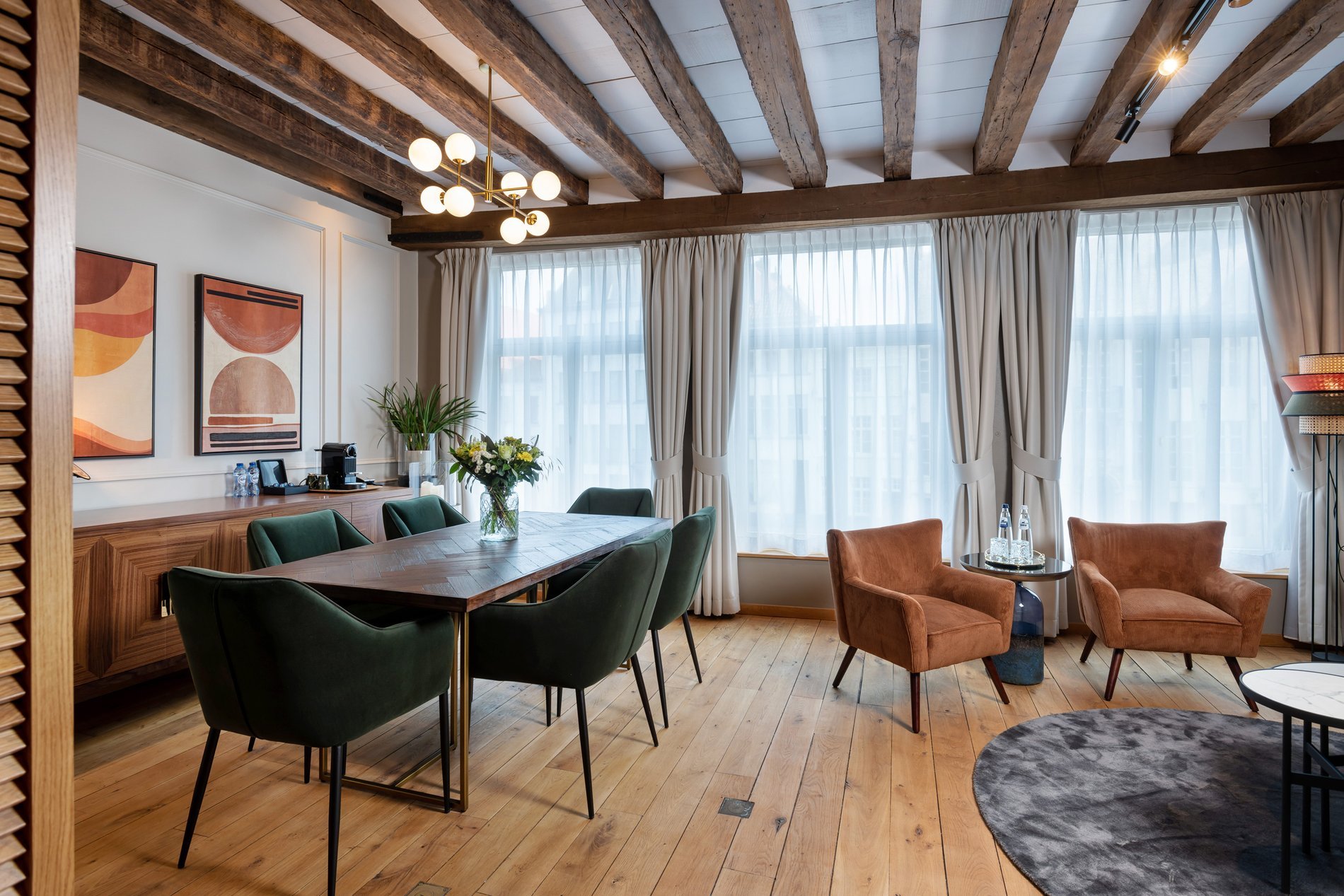Partie élégante de la suite avec poutres apparentes et espace salon à Martin’s Relais.