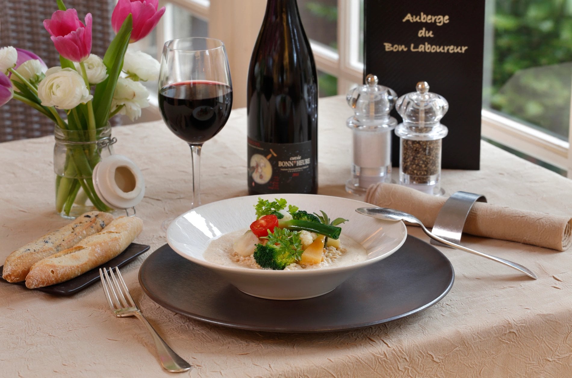 Table set with a gourmet dish and a bottle of wine at Auberge du Bon Laboureur in Chenonceaux
