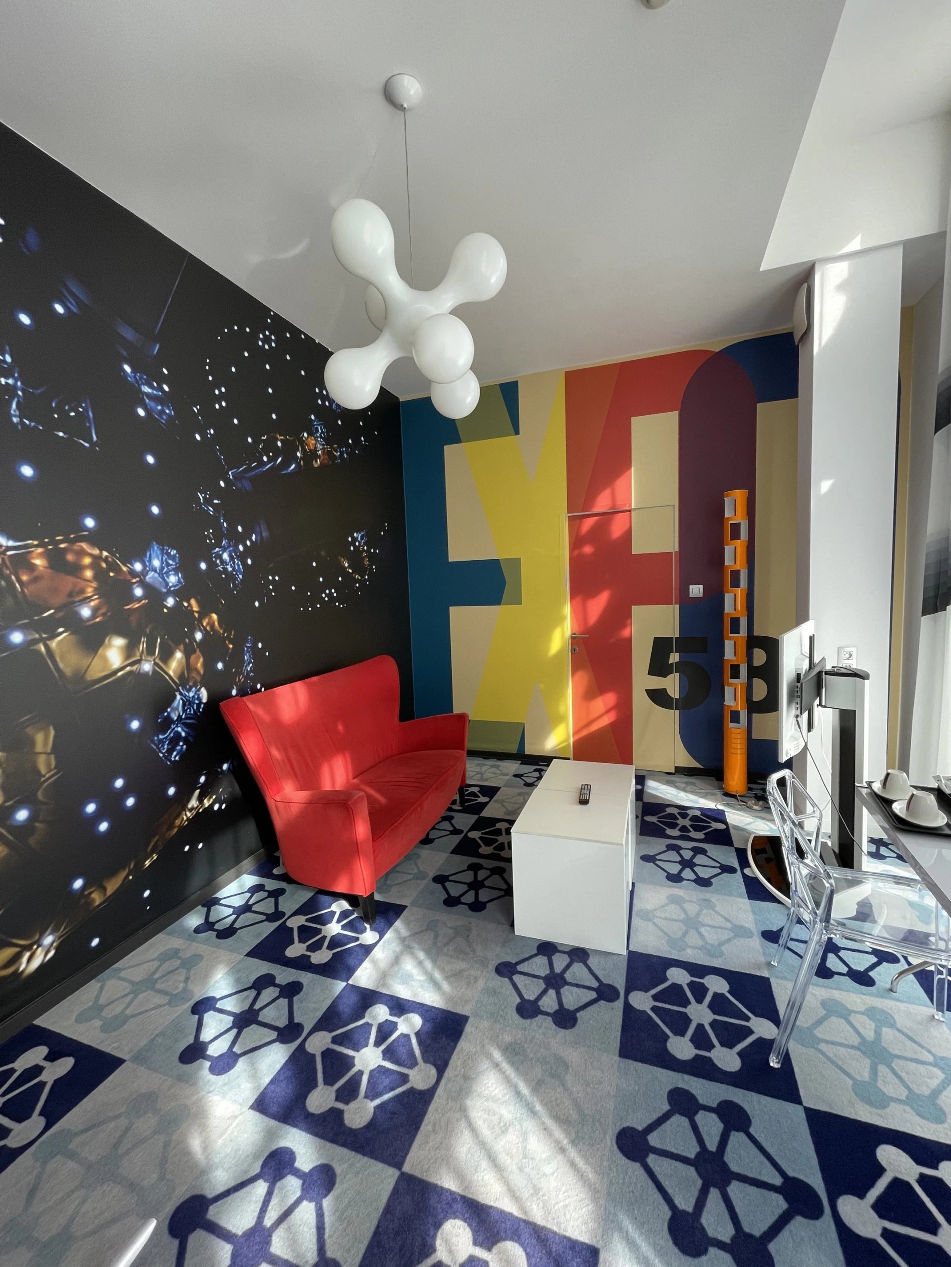 Helles Zimmer mit künstlerischer Dekoration und bunten Möbeln.