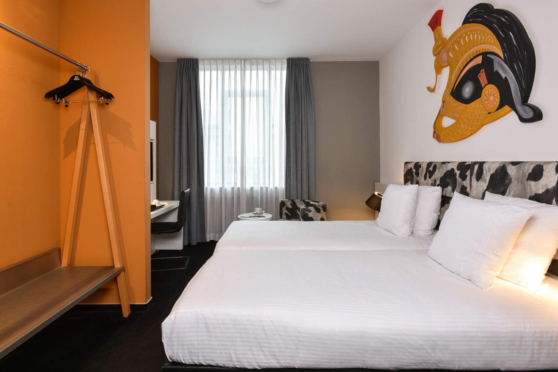 Gemütliches Plus-Zimmer mit Doppelbett und dekorativer Wand.