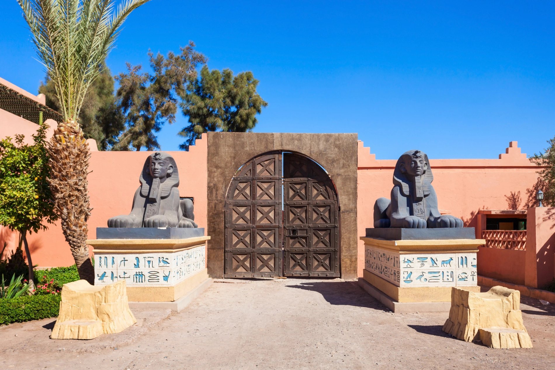 Entrée décorée avec statue et palmiers au Berbère Palace à Ouarzazate