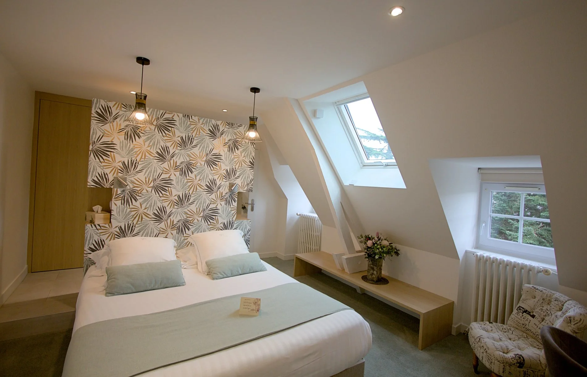 Chambre Standard mansardée de l'Hôtel La Ramade avec fenêtre de toit, symbolisant un espace douillet sous les combles.
