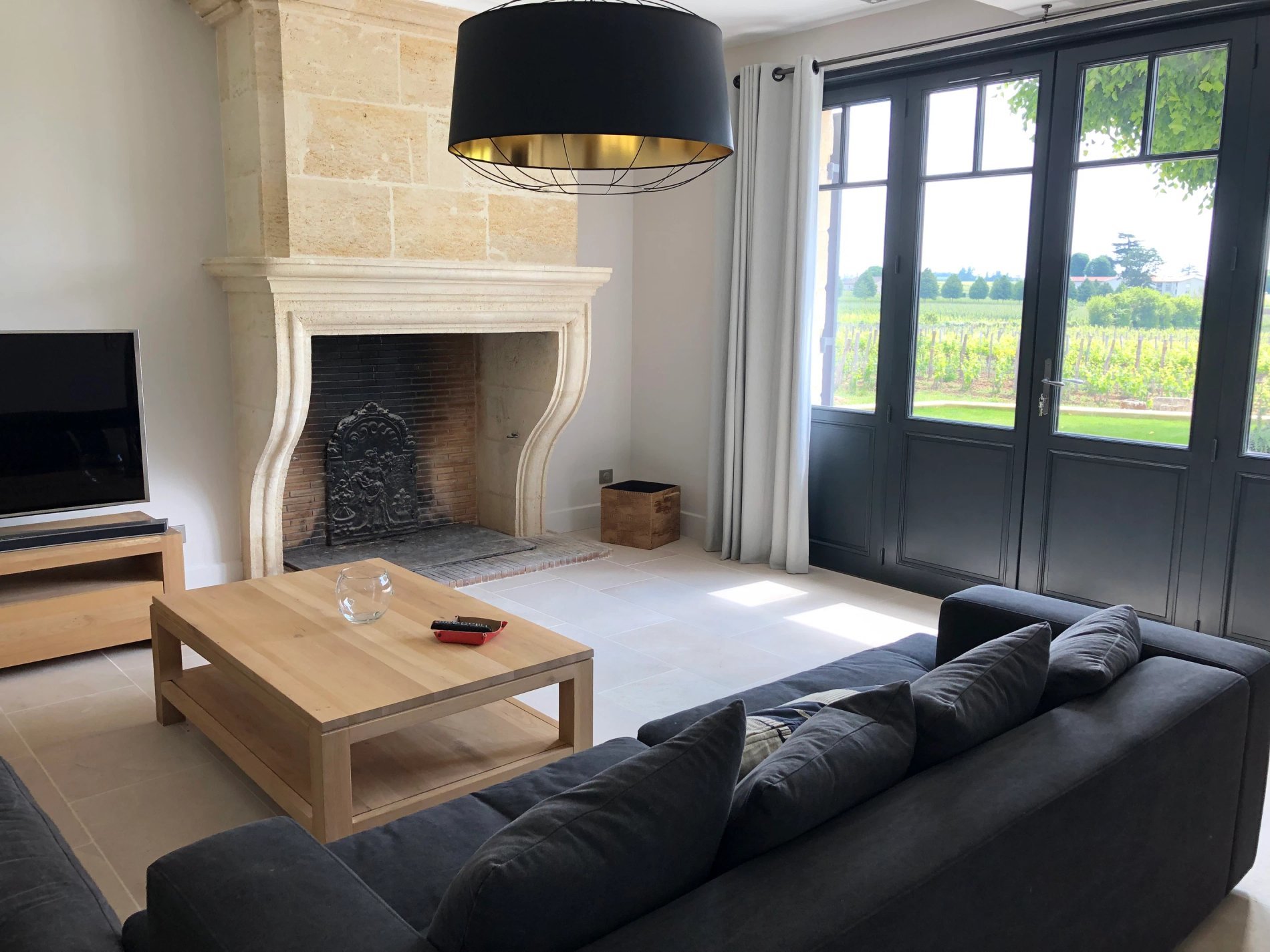 Salon élégant avec cheminée à La Maison du Château Soutard-Cadet