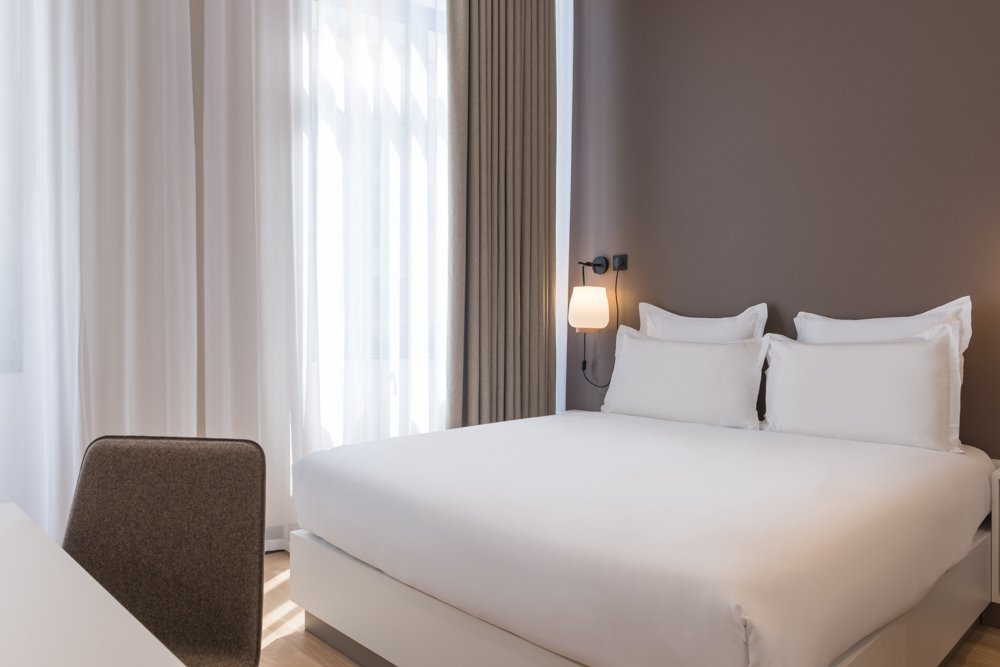 Chambre Masterpiece, lumineuse et spacieuse de 25m², offrant un espace de douche ouvert sur la chambre et toilettes séparées.