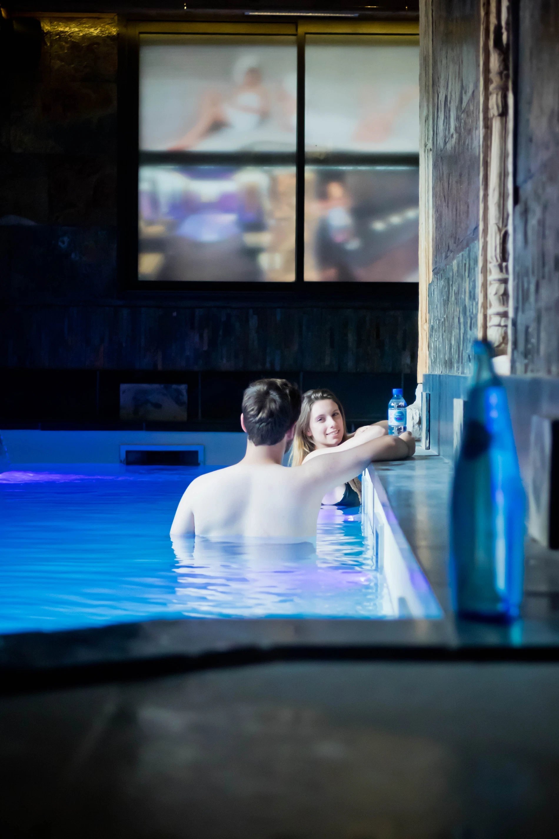 Couple relaxing in the swimming pool of the Hôtel SPA Le Lion d'Or.