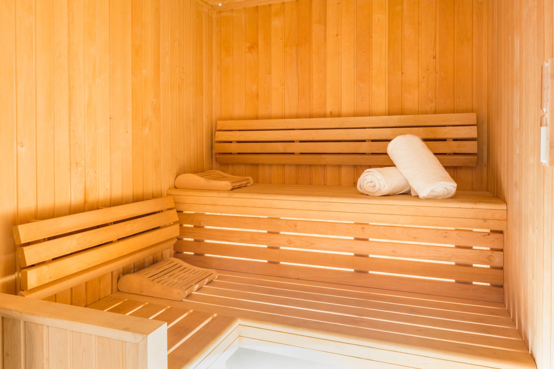 Sauna en bois clair avec serviettes, symbolisant l'espace de relaxation de BW La Demeure Paris.