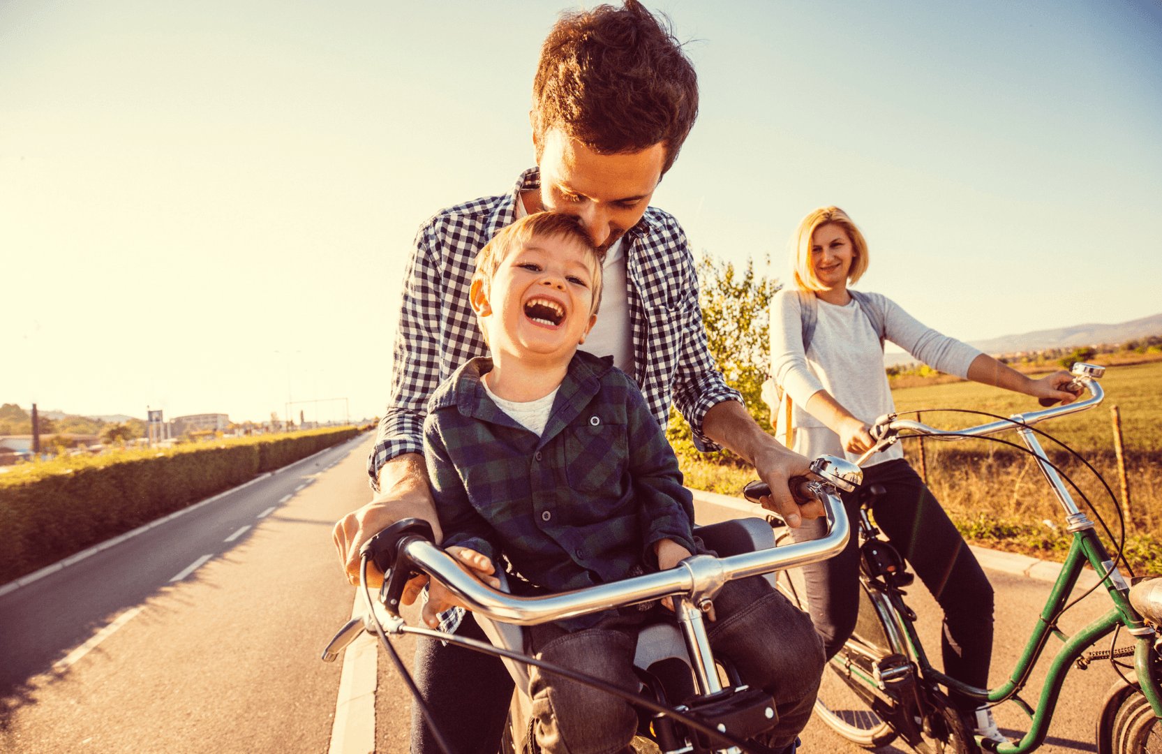 Famille heureuse faisant du vélo sur une route ensoleillée