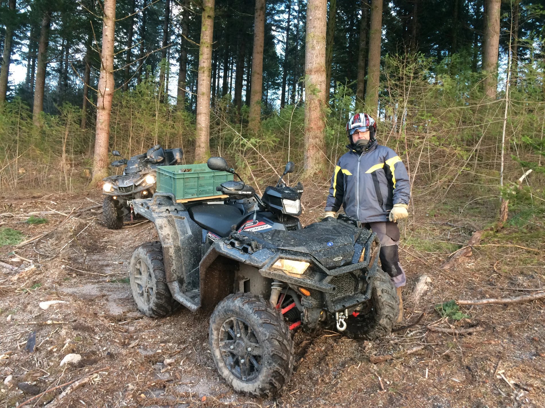 Participant en combinaison devant un quad stationné en forêt, activité proposée par Villa Corrèze Aventure.