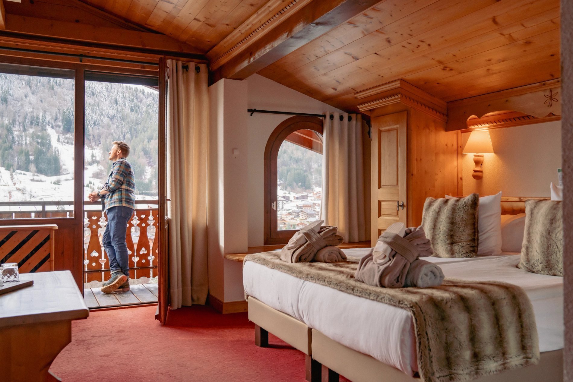 Chambre Privilège de l'hôtel Le Dahu avec décoration alpine et vue panoramique sur le village