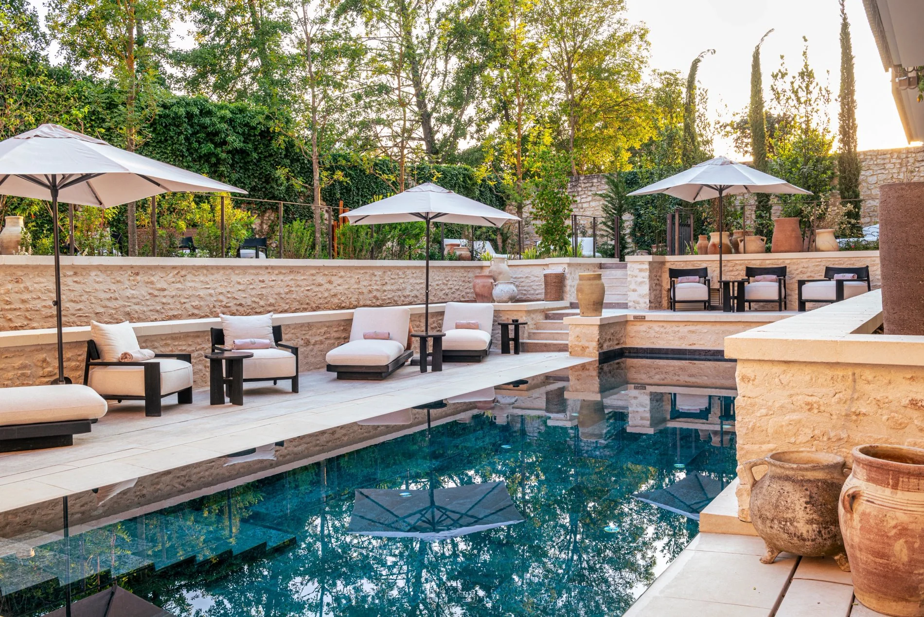 Espace piscine ombragé par des parasols, entouré de nature à L'Isle de Leos