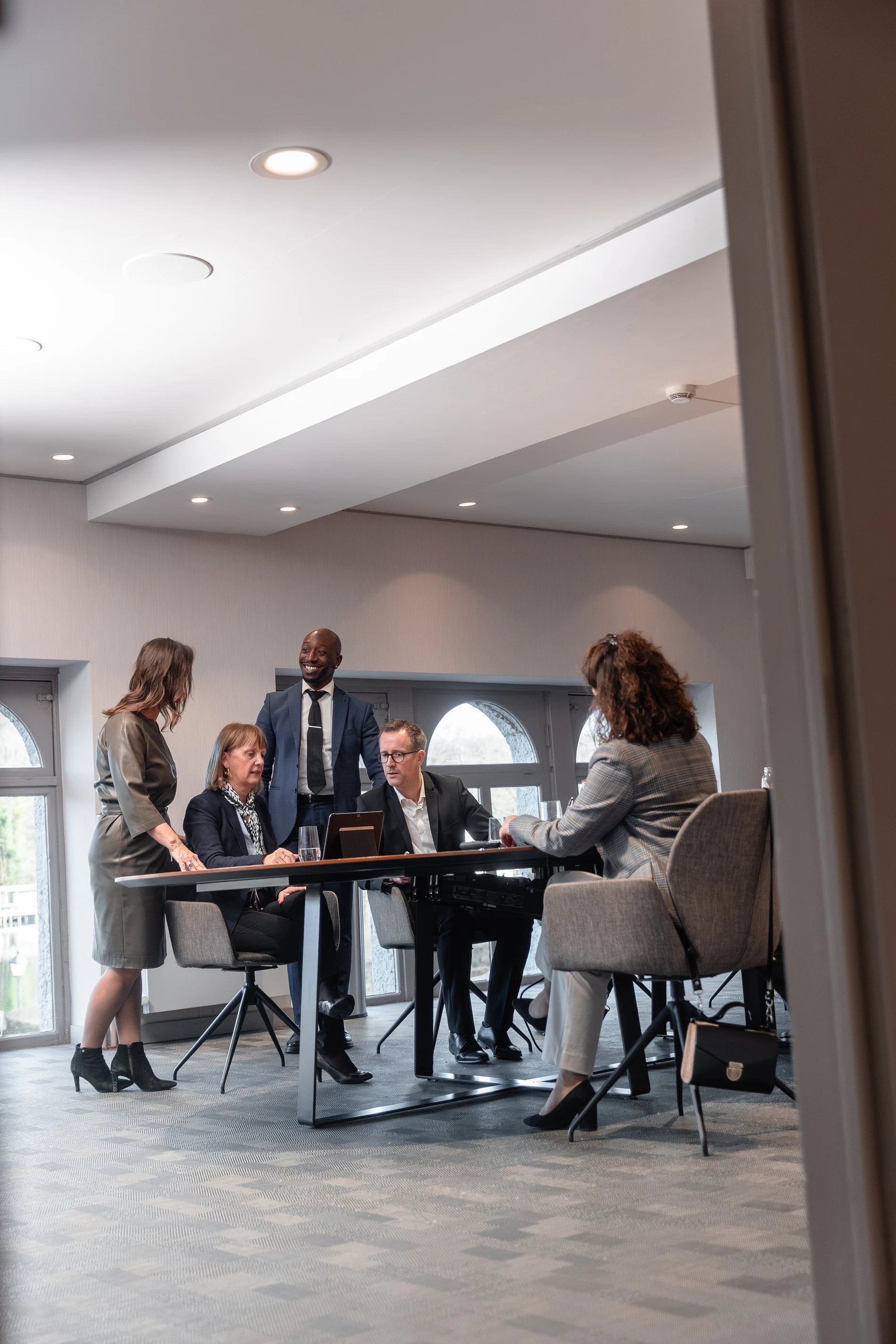 Salle de réception illuminée avec des invités attablés pour un événement festif.