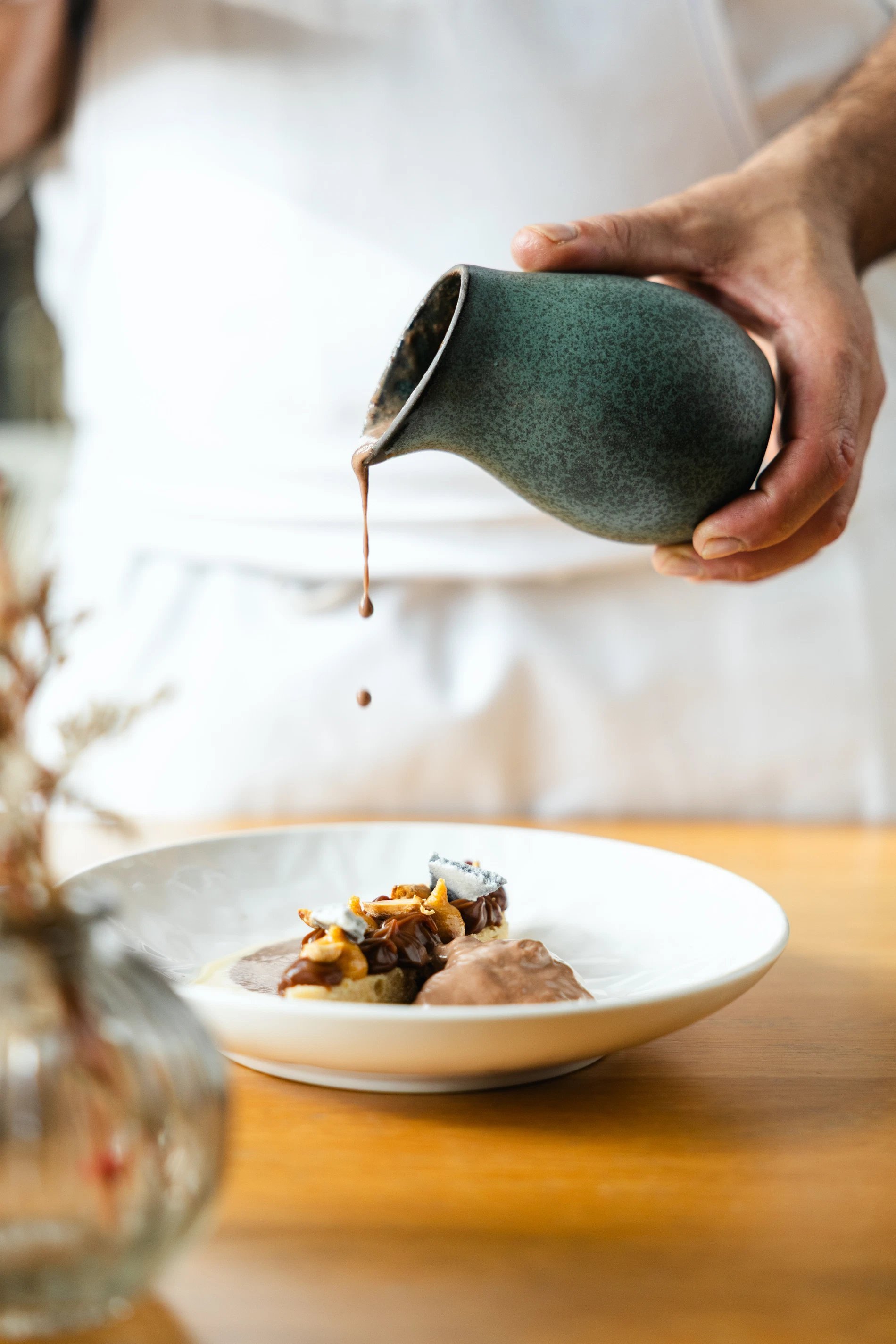 Chef versant une sauce sur un plat gastronomique dans un restaurant à La Rochelle