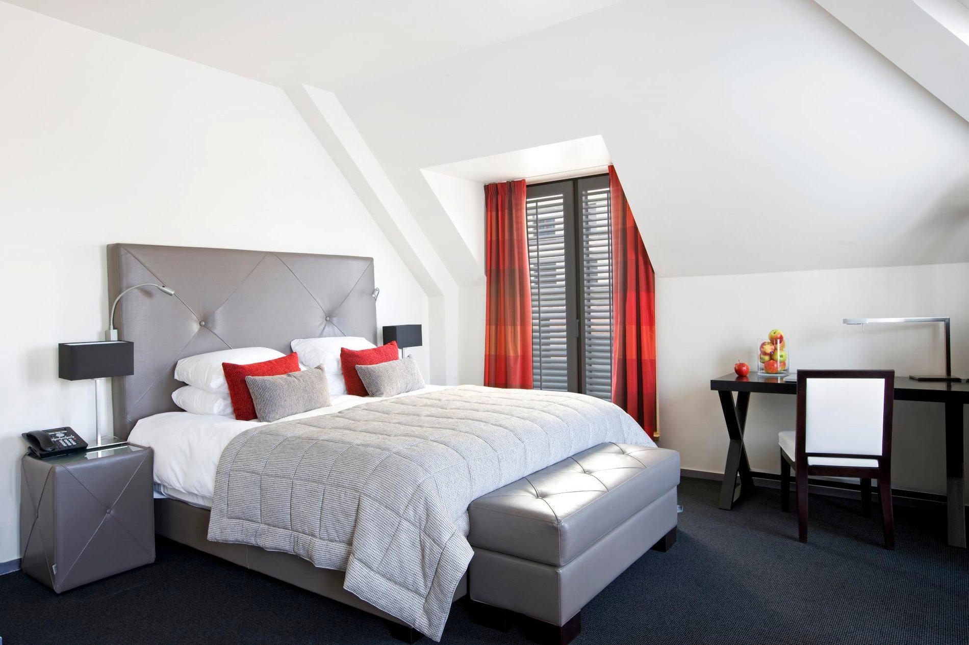 Chambre moderne avec des touches rouges au Martin's Klooster à Louvain.