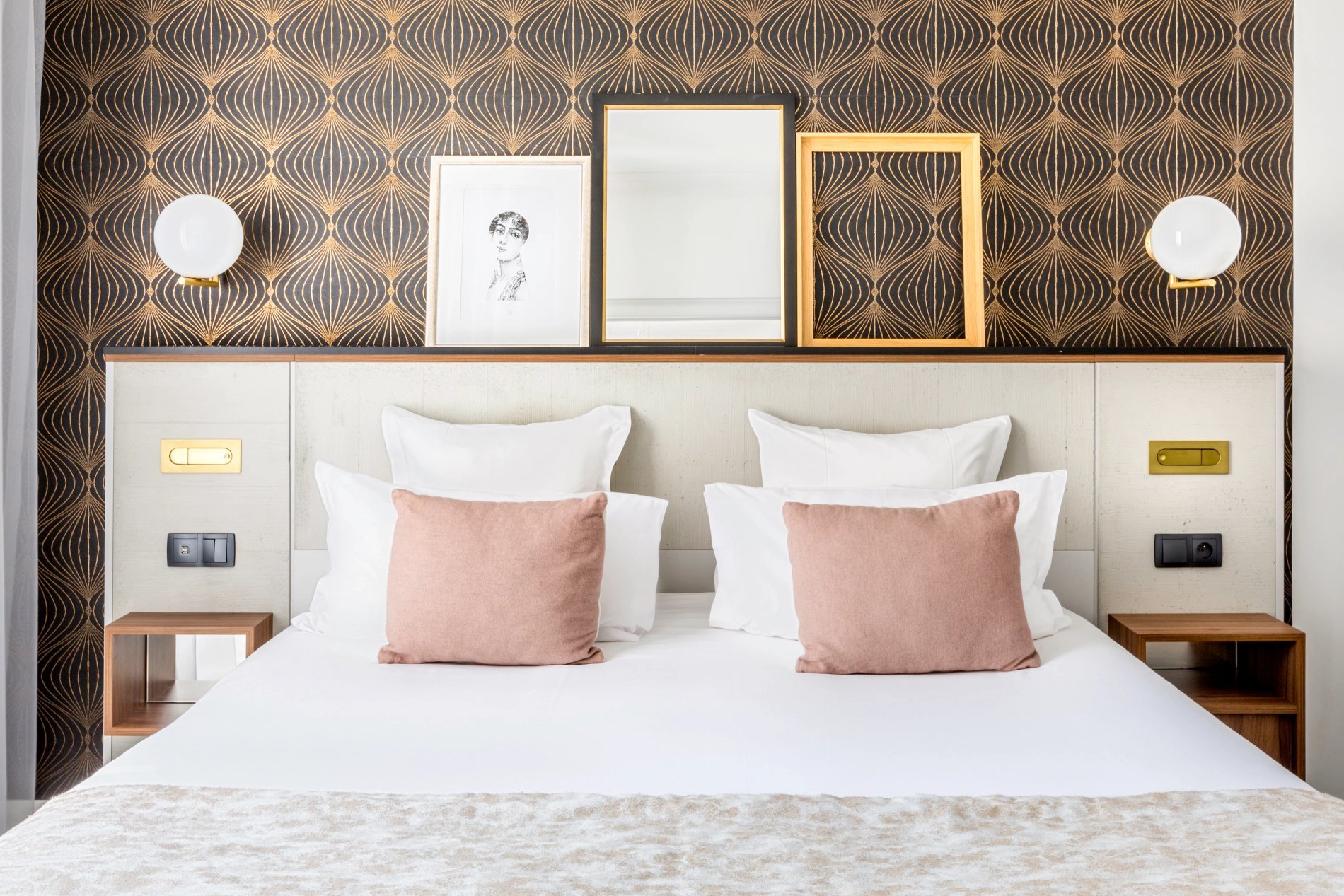 Lit double avec oreillers roses et têtes de lit décorées, symbolisant les suites confortables de BW La Demeure Paris.