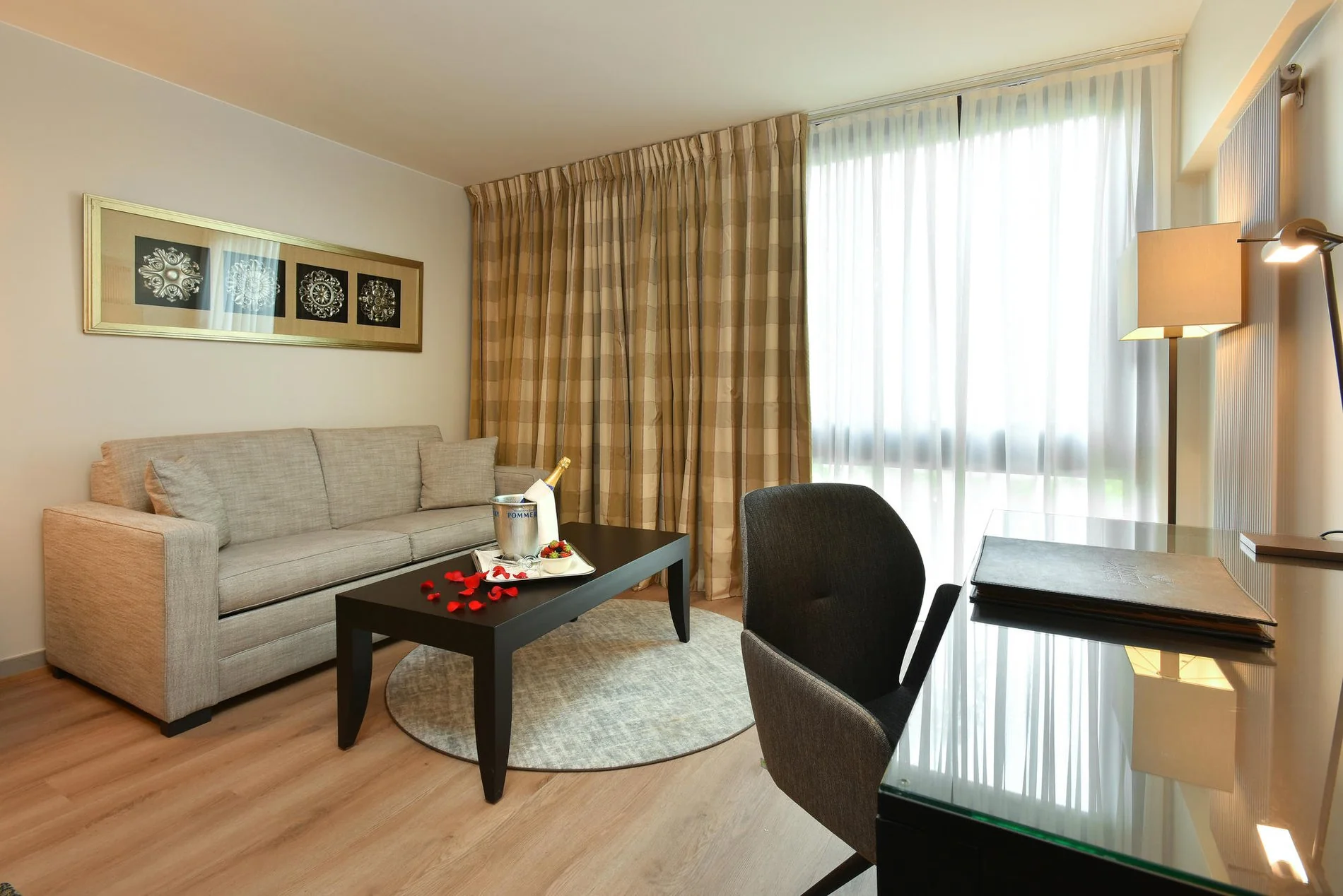 Lichte zithoek met beige bank en bureau in de Great Lake View-kamer.
