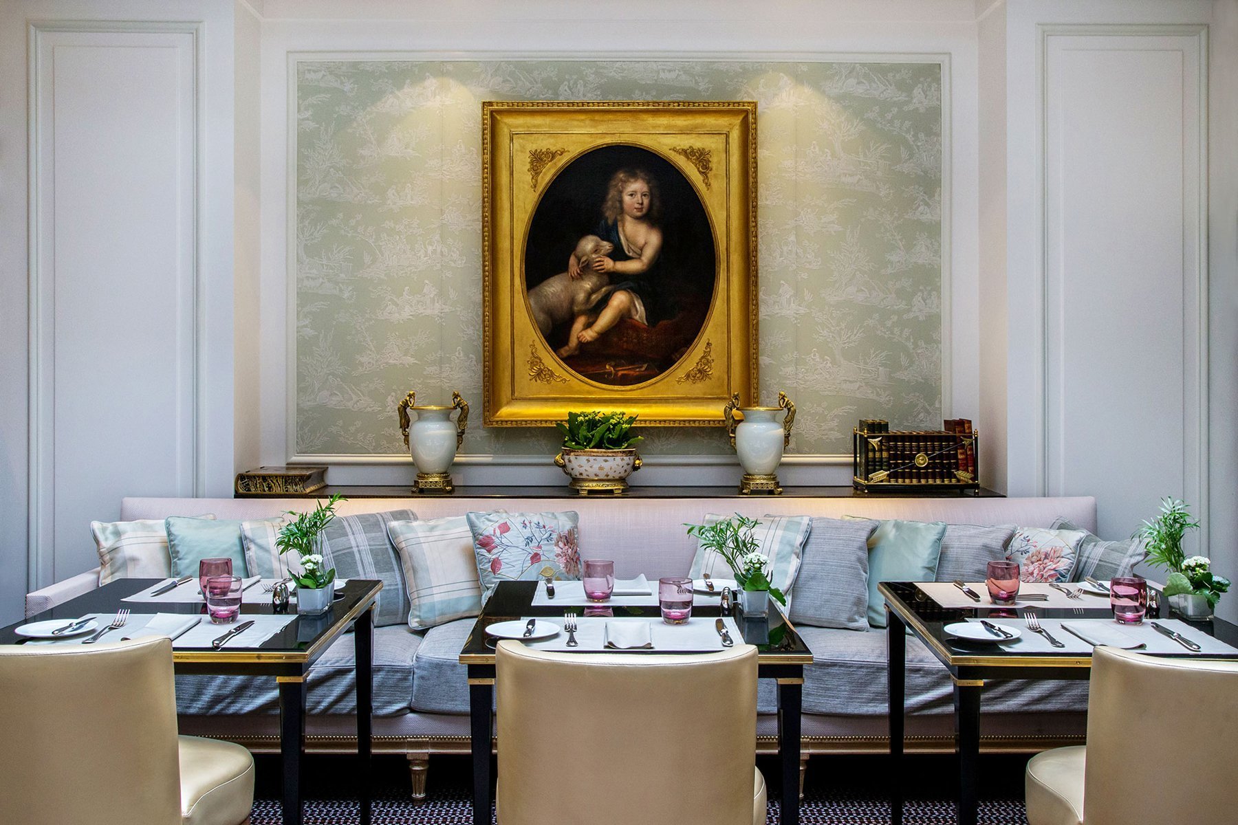 Bright dining room at Les Confidences, Hôtel San Régis, with elegant ambiance and classic artwork.