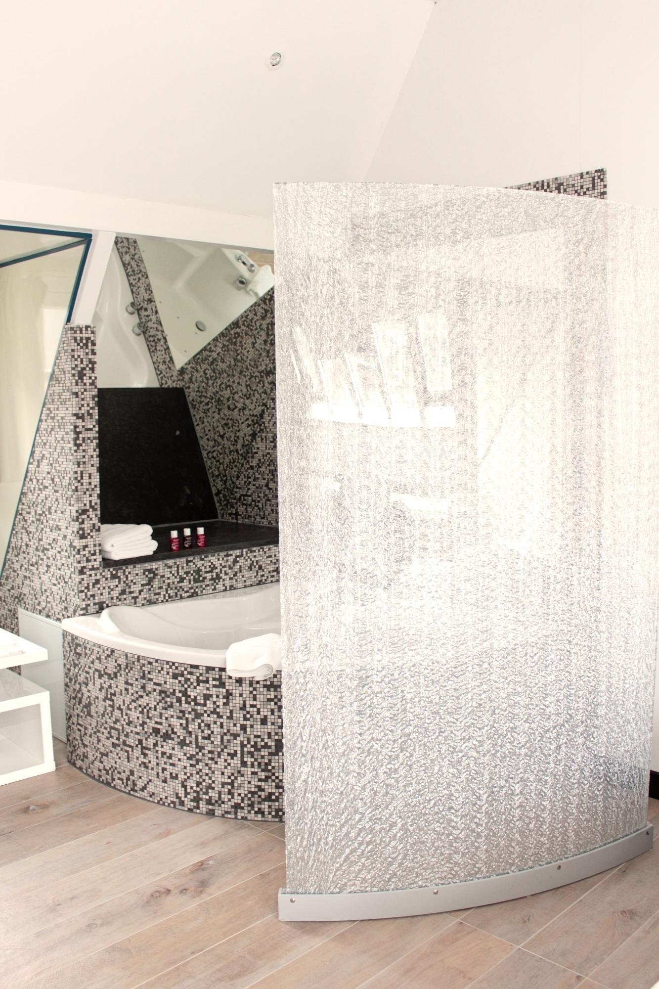 Zeitgenössisches Badezimmer mit Badewanne und eleganten Mosaiken.