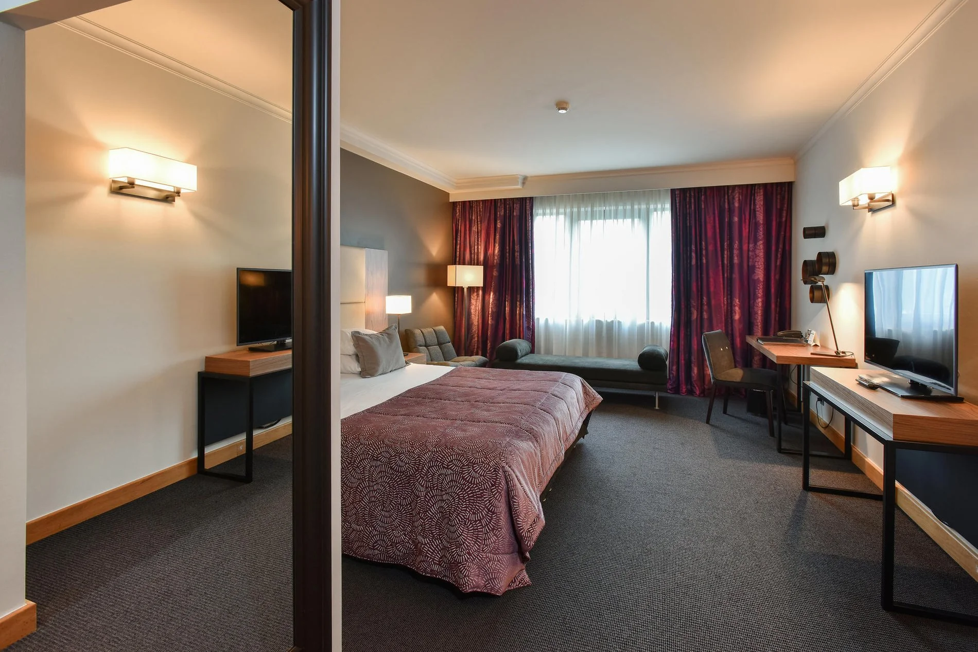 Gezellige kamer met tweepersoonsbed en sobere inrichting bij Martin's Château du Lac.