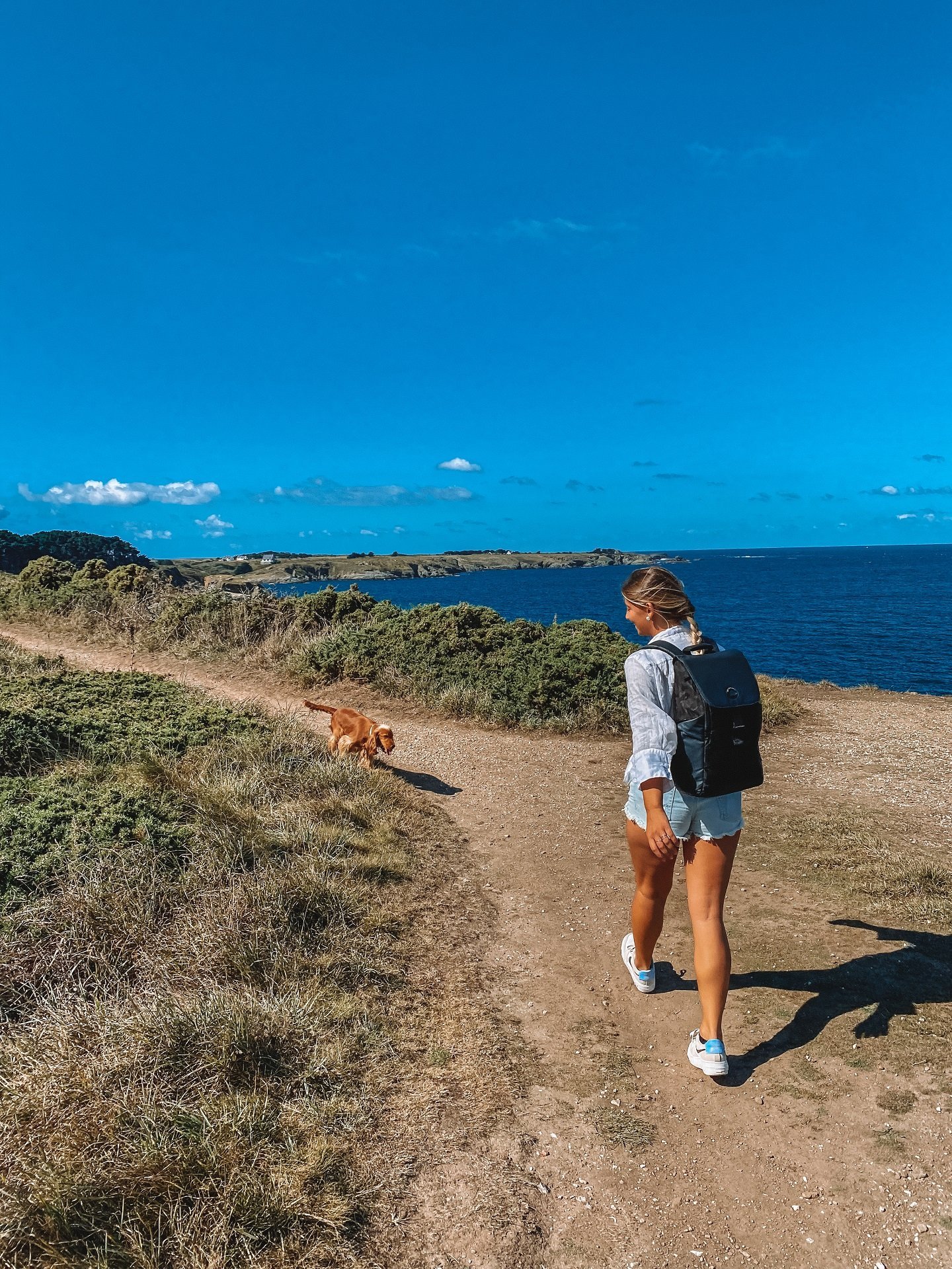 Randonneuse sur le sentier du GR 340 à Belle-Île-en-Mer avec panorama sur la mer