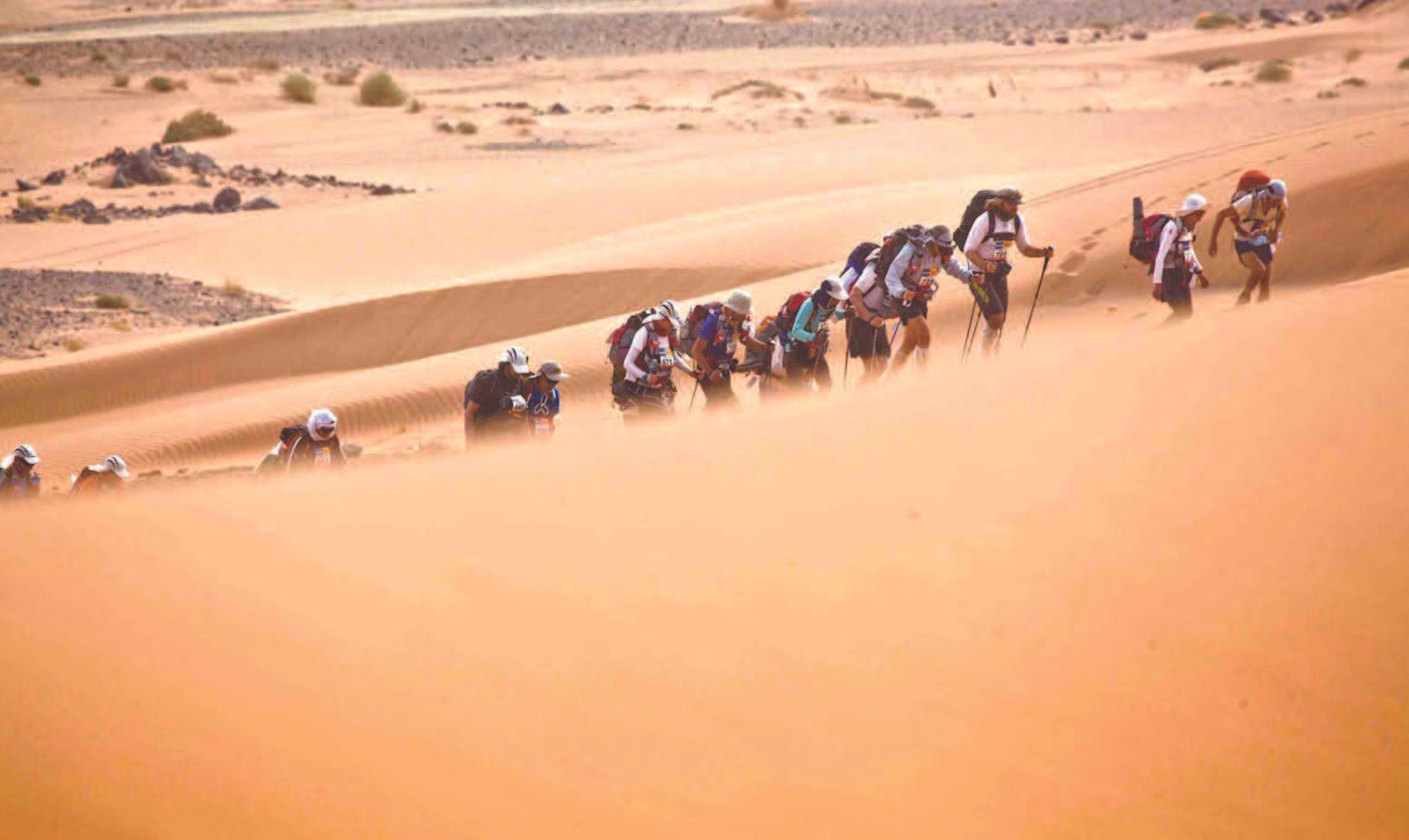 Caravane de voyageurs traversant les dunes du désert près du Berbère Palace