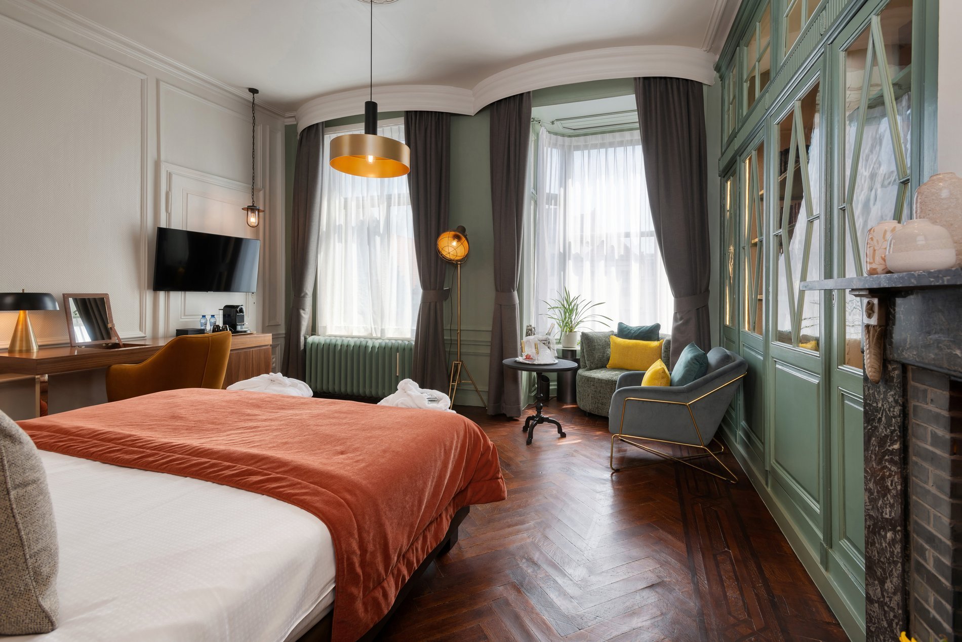 Chambre lumineuse avec parquet en bois et coin détente à Martin’s Relais.