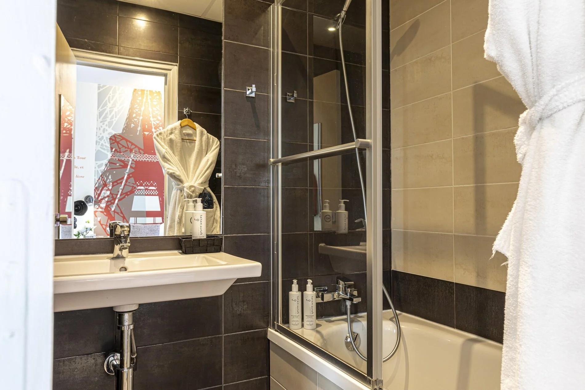 Salle de bain de la Junior Suite de l'Hôtel Alpha Paris Eiffel avec baignoire.
