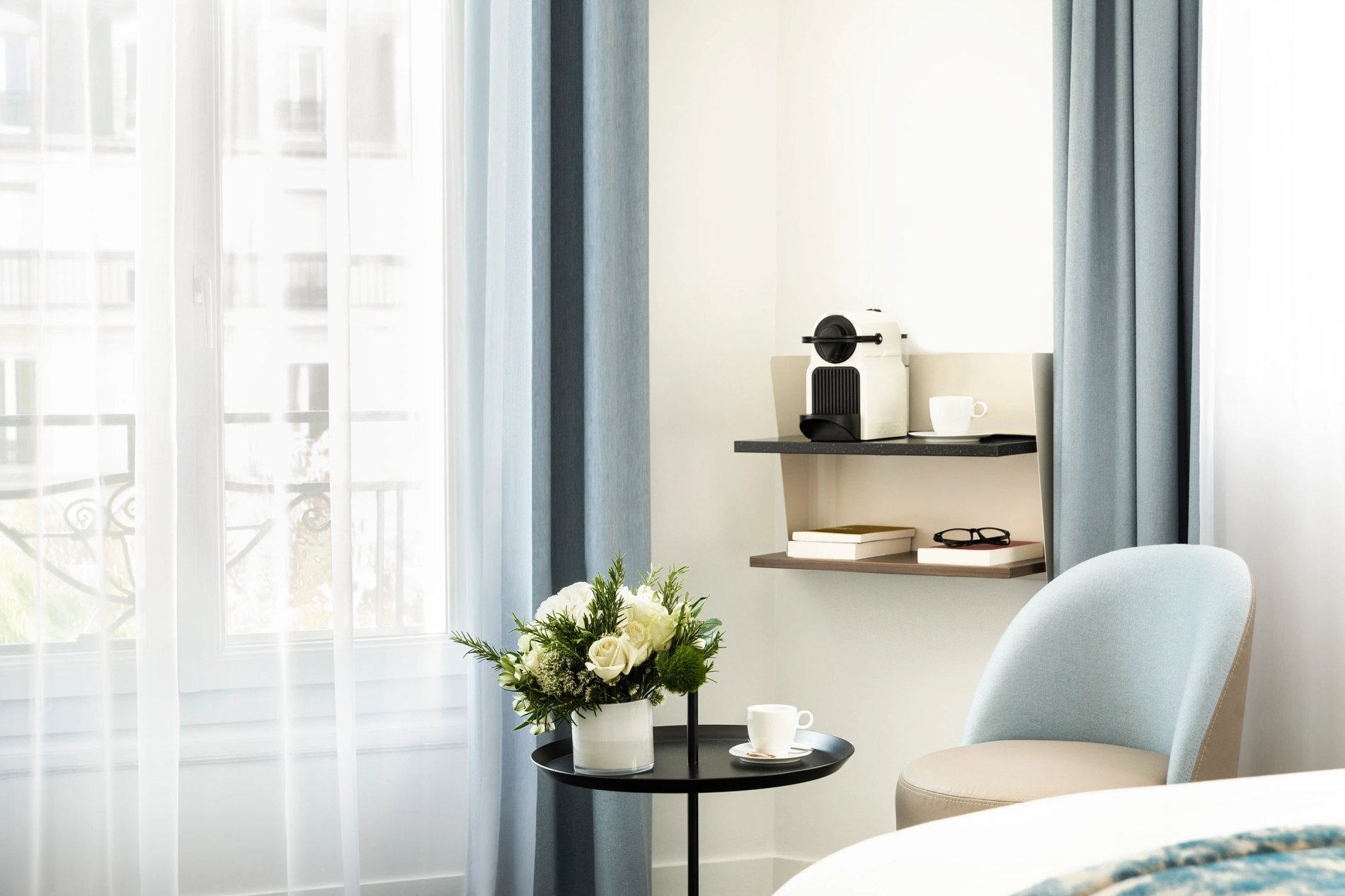 Chambre supérieure avec coin salon et balcon, symbolisant l'hébergement élégant de BW La Demeure Paris.