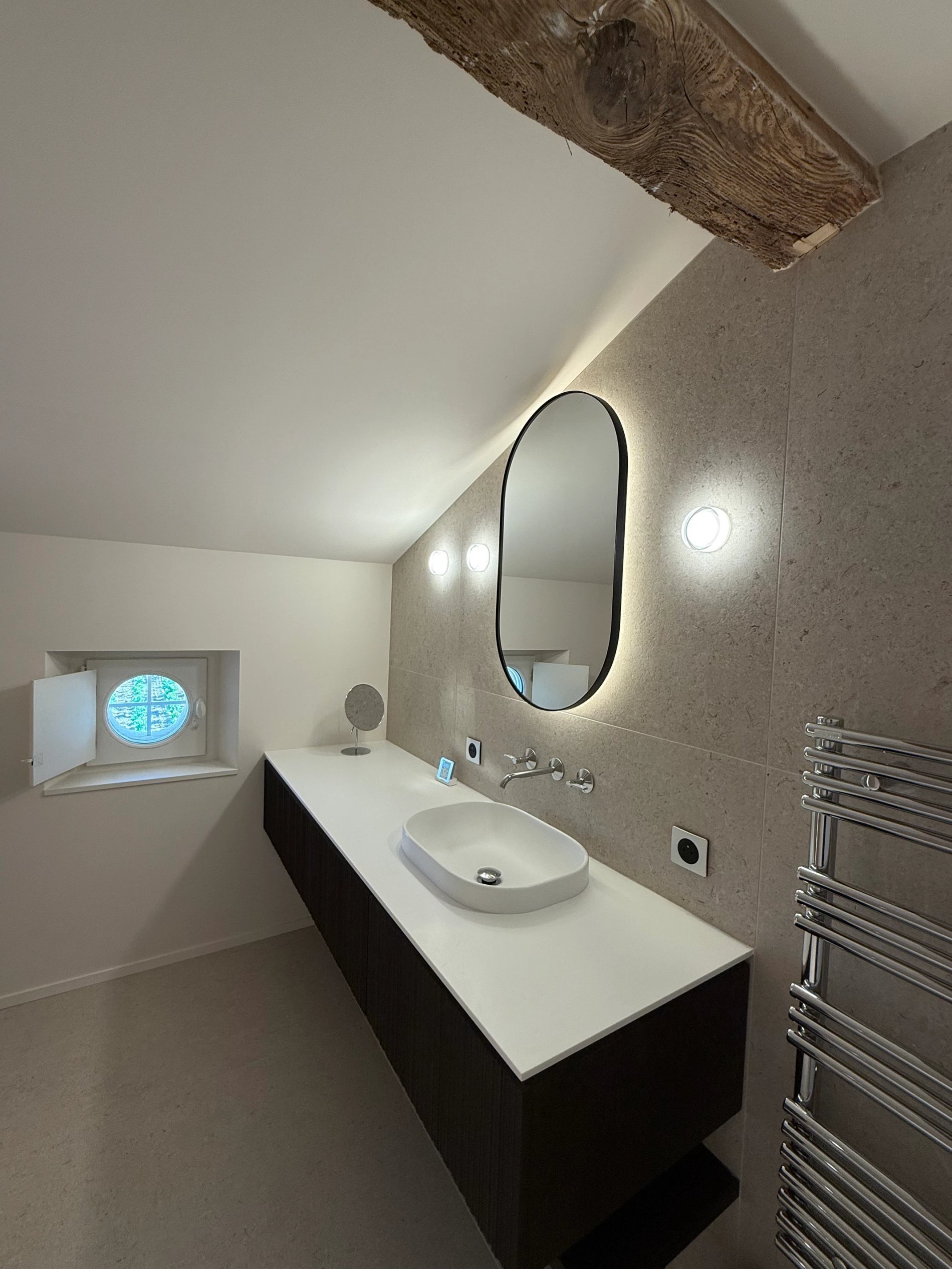 Salle de bain élégante avec double vasque et miroir ovale dans la Suite Prestige de la Villa des Vignes