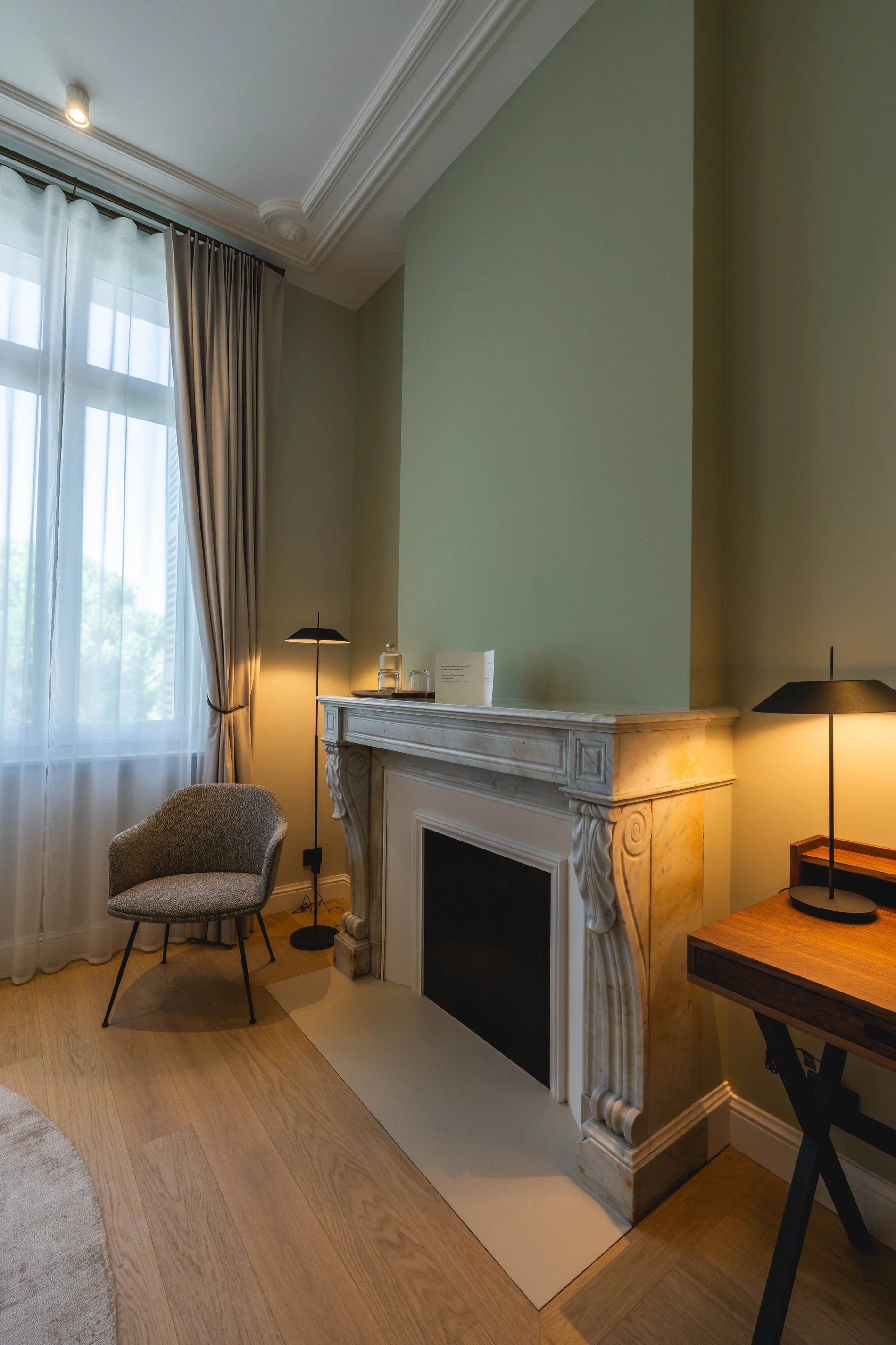 Coin détente avec fauteuil et cheminée dans la Chambre Essentielle à la Villa des Vignes