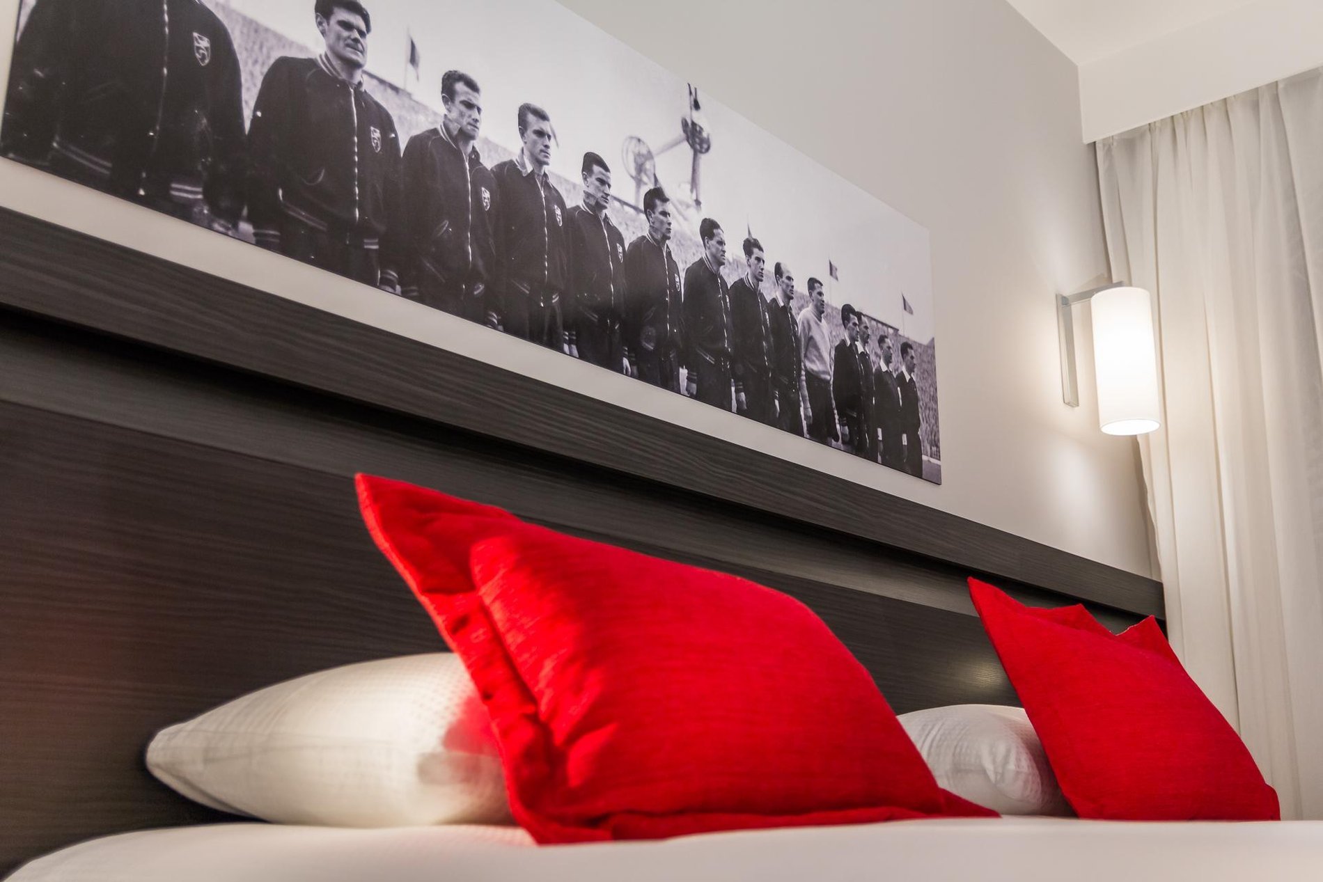 Double bed with red pillows and modern decor in a Charming Quadruple room at Martin's Red.