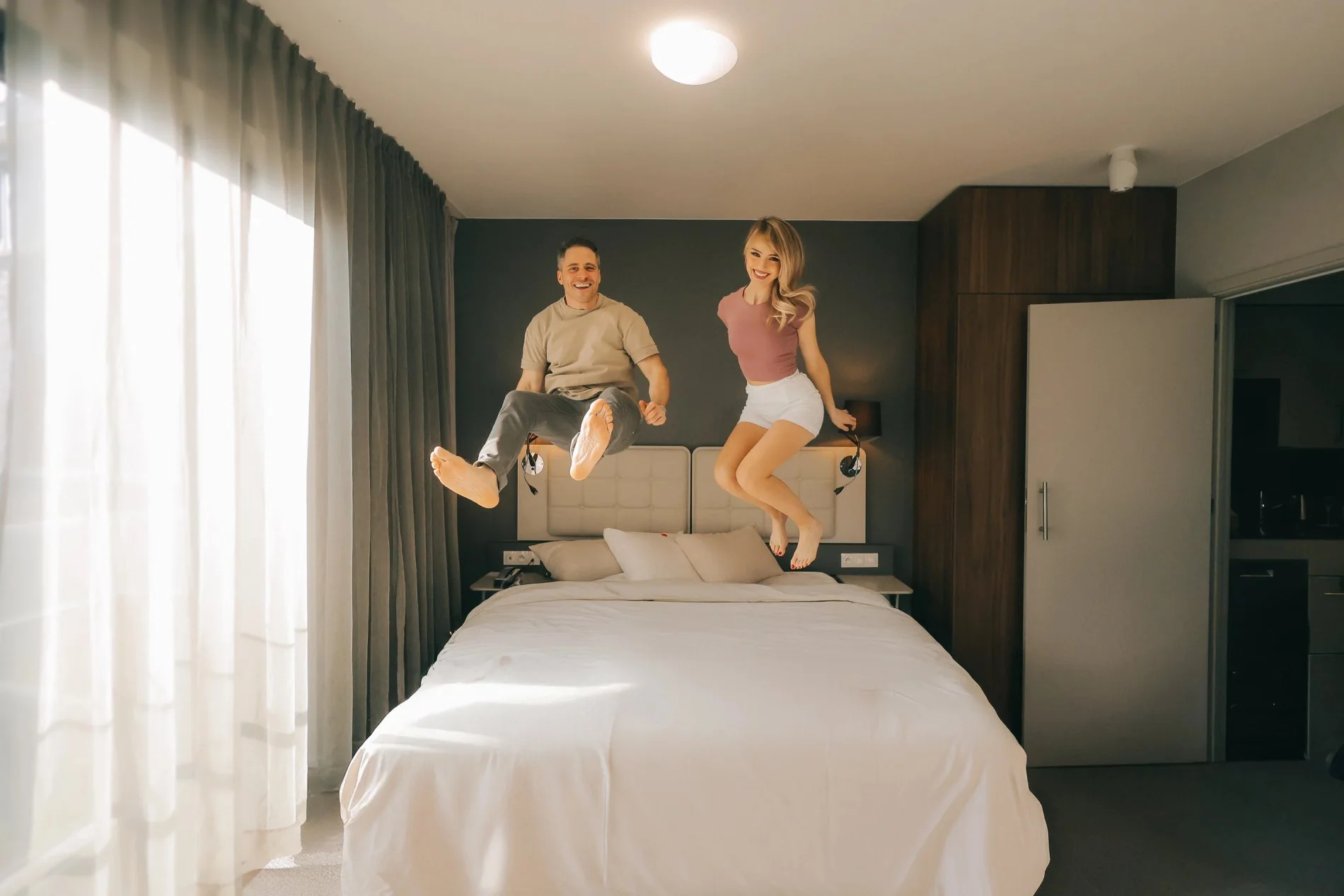 Chambre confortable avec lit double, lampes et rideaux élégants.