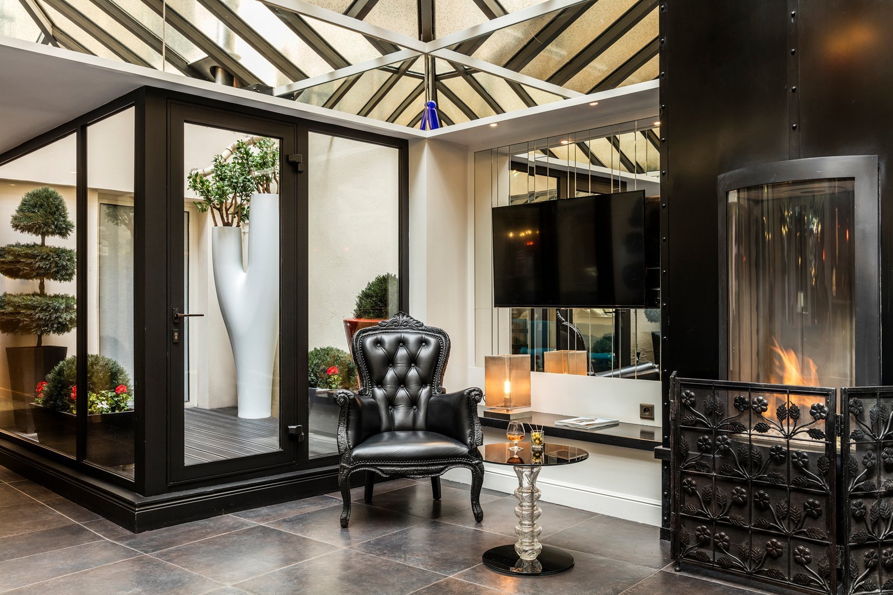 Designer lounge with fireplace and chic armchair in the lounge of the Hôtel Louvre Saint-Honoré, boutique hotel in Paris 1st district