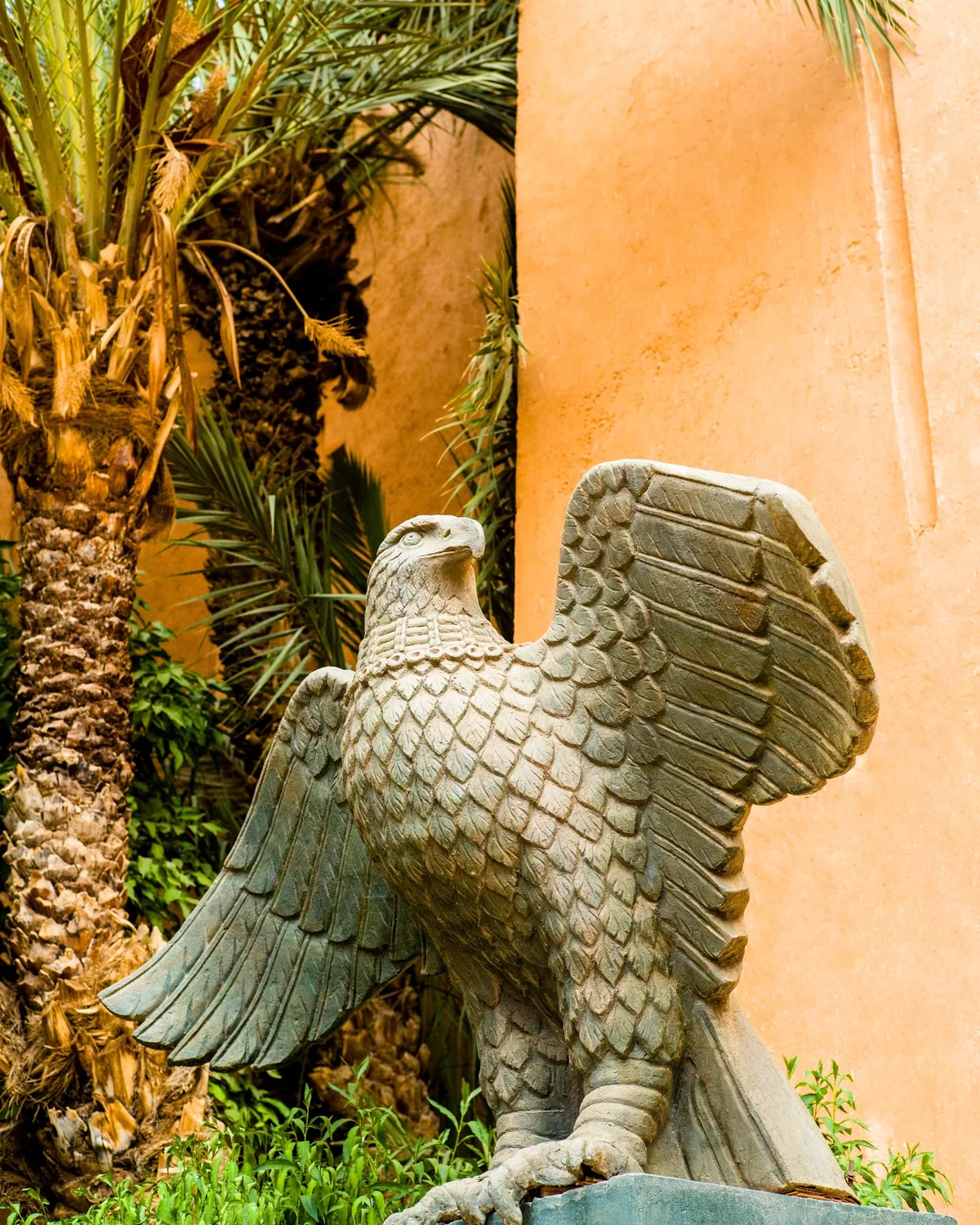 Le Berbère Palace, Stone eagle sculpture under palm trees at Berbère Palace