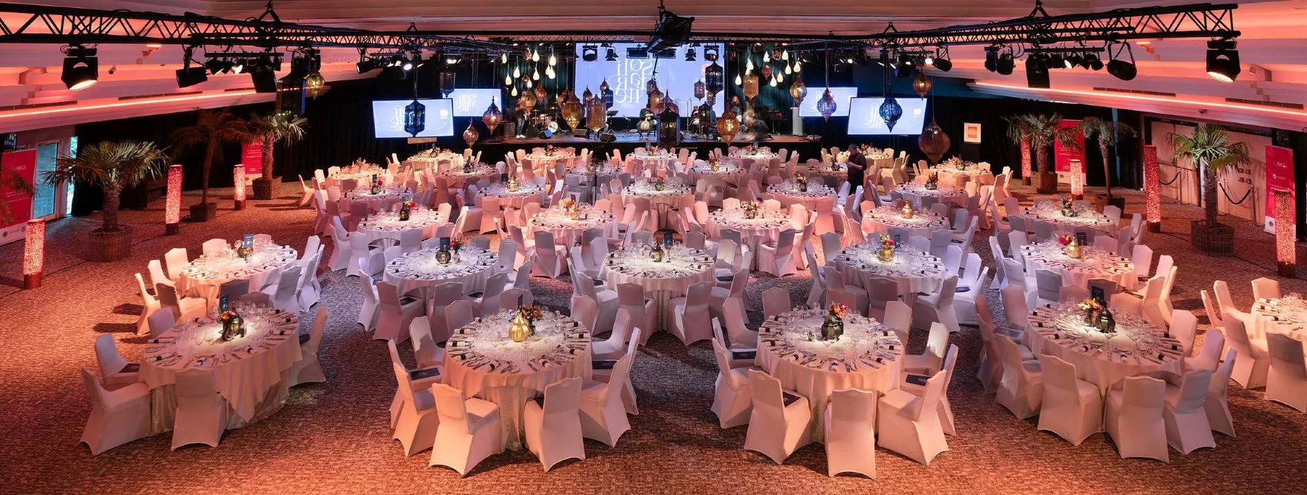Elegant reception hall at Martin's Château du Lac decorated for a wedding with tables and lights.