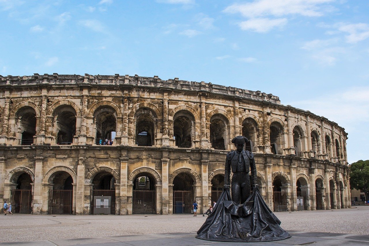 View of the Nîmes Arena with the bullfighter statue in the foreground.
