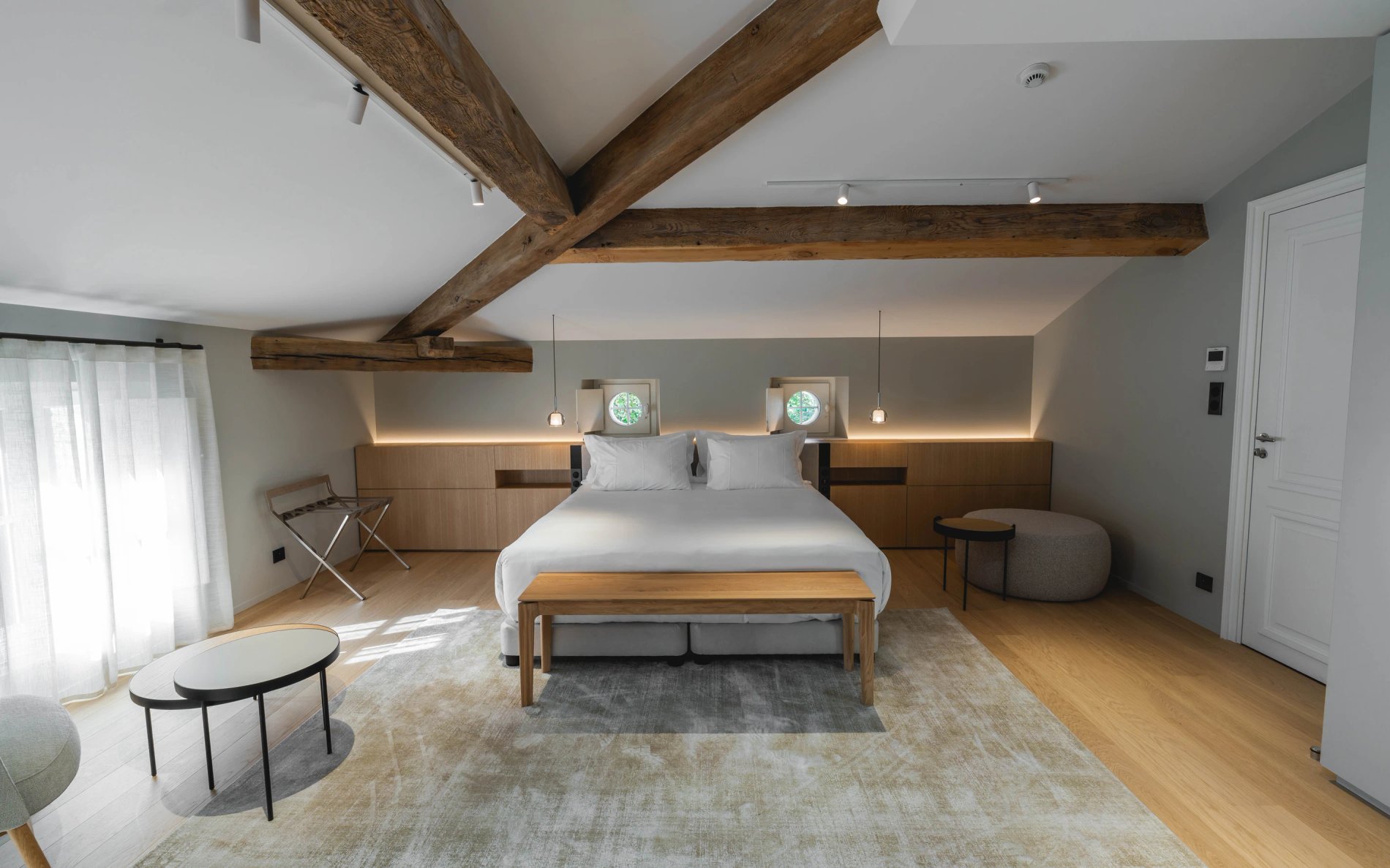 Lit double sous poutres apparentes dans la Suite Élégance de la Villa des Vignes à Saint-Émilion