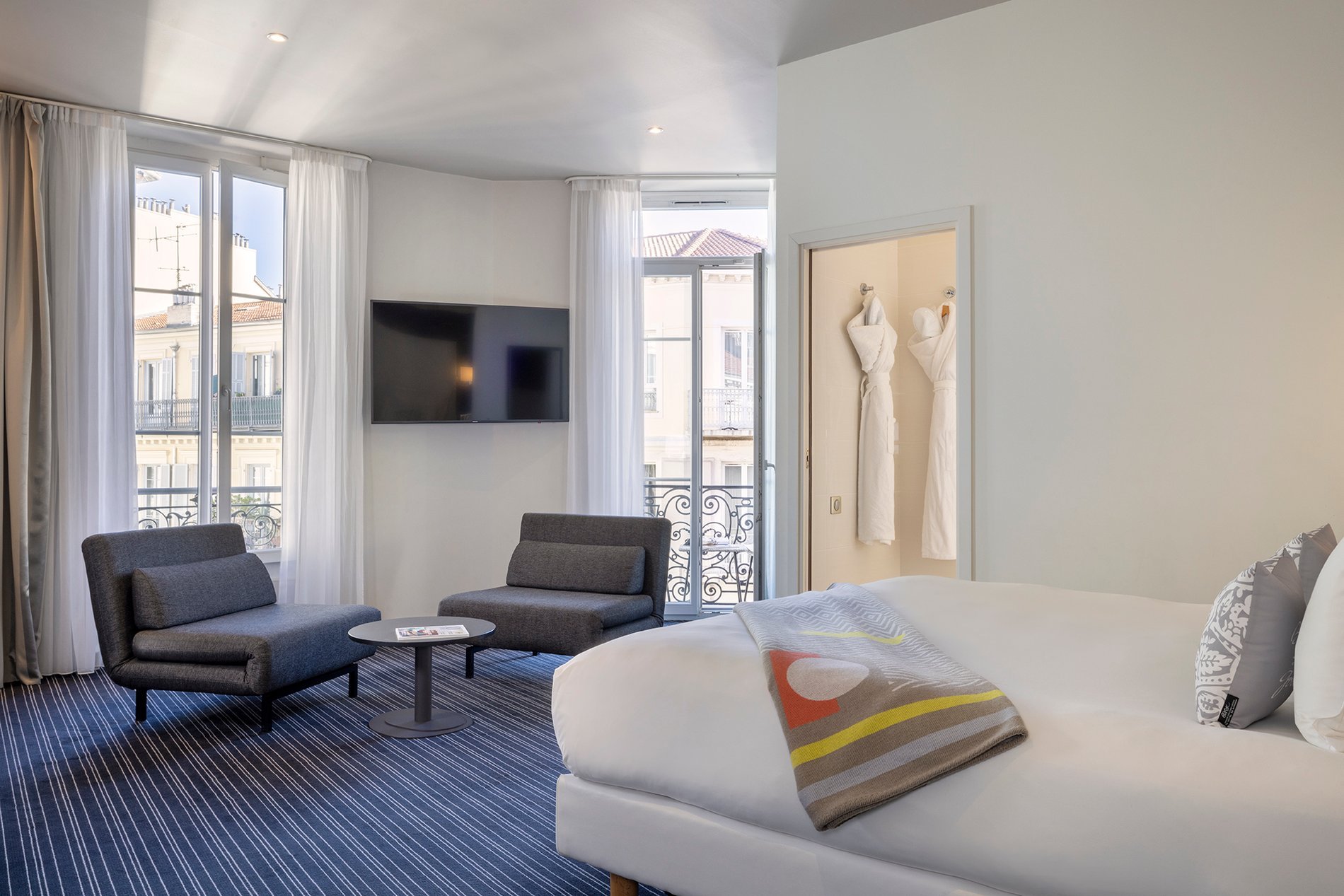 Chambre spacieuse et lumineuse de l’Hôtel 64 à Nice avec coin salon contemporain